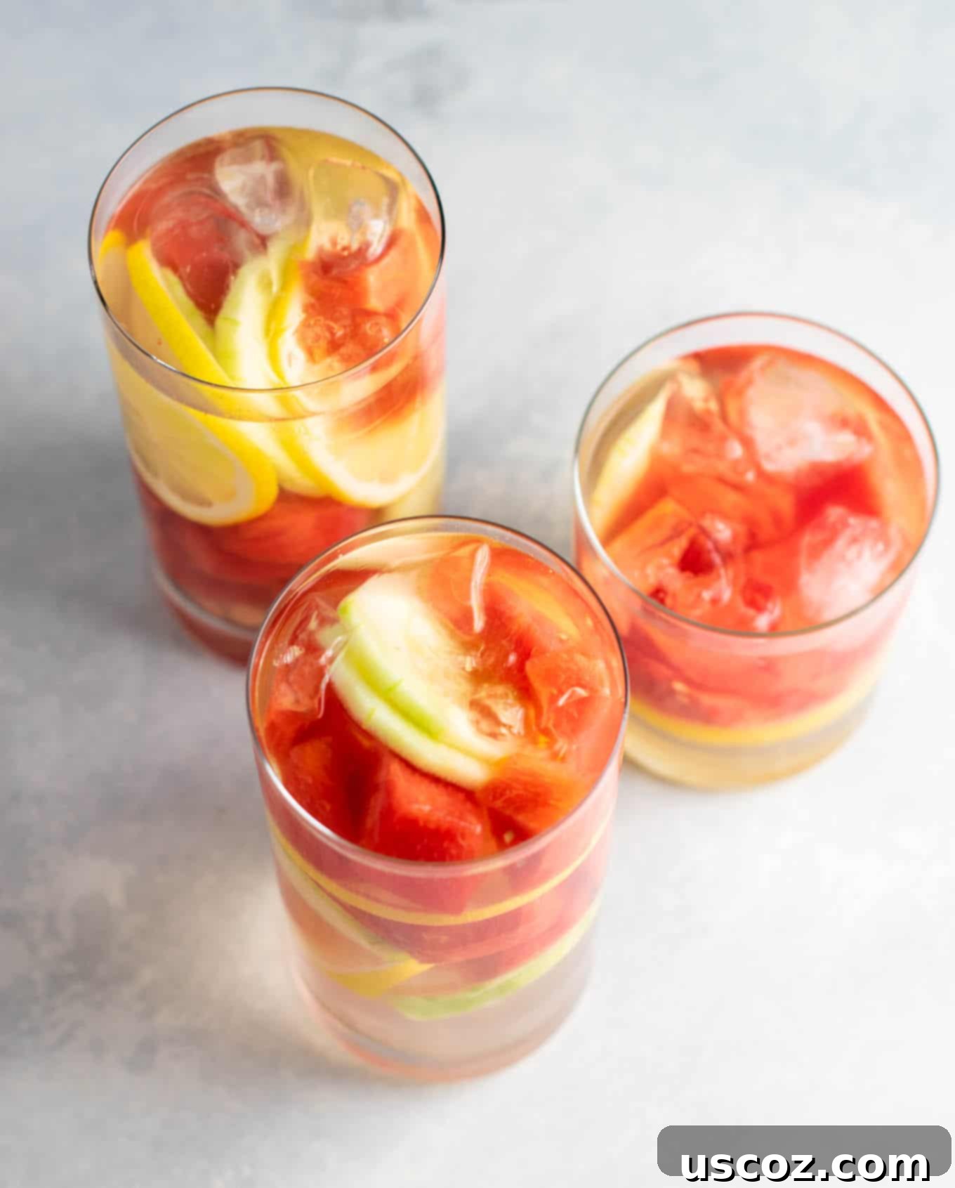 Hydrating Watermelon Detox Elixir 6 Ingredients for Watermelon Detox Water laid out: fresh cut watermelon, sliced cucumber, and a whole lemon. Highlighting the simple, healthy components.