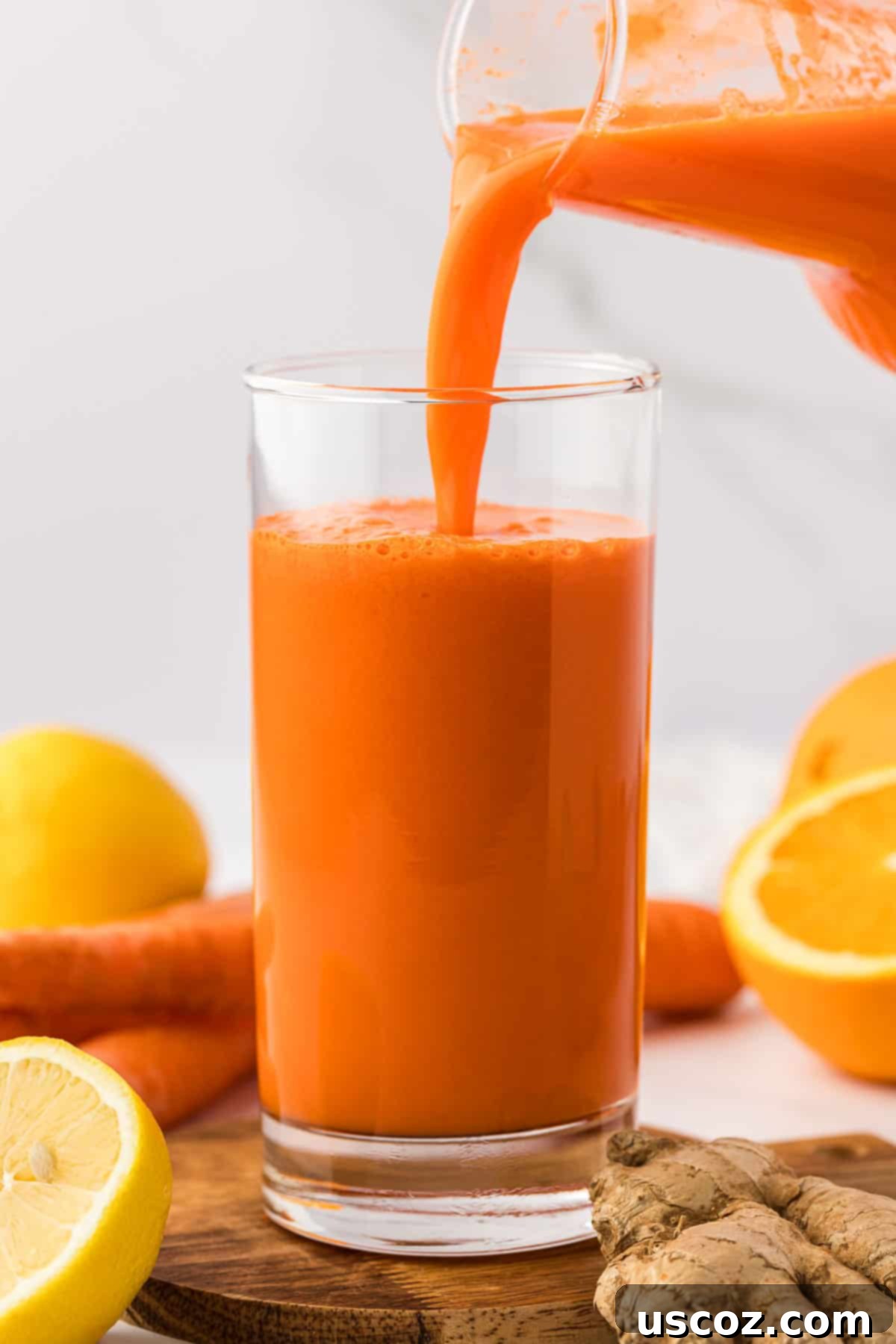 Golden Glow Juice 6 pouring carrot orange juice into a glass