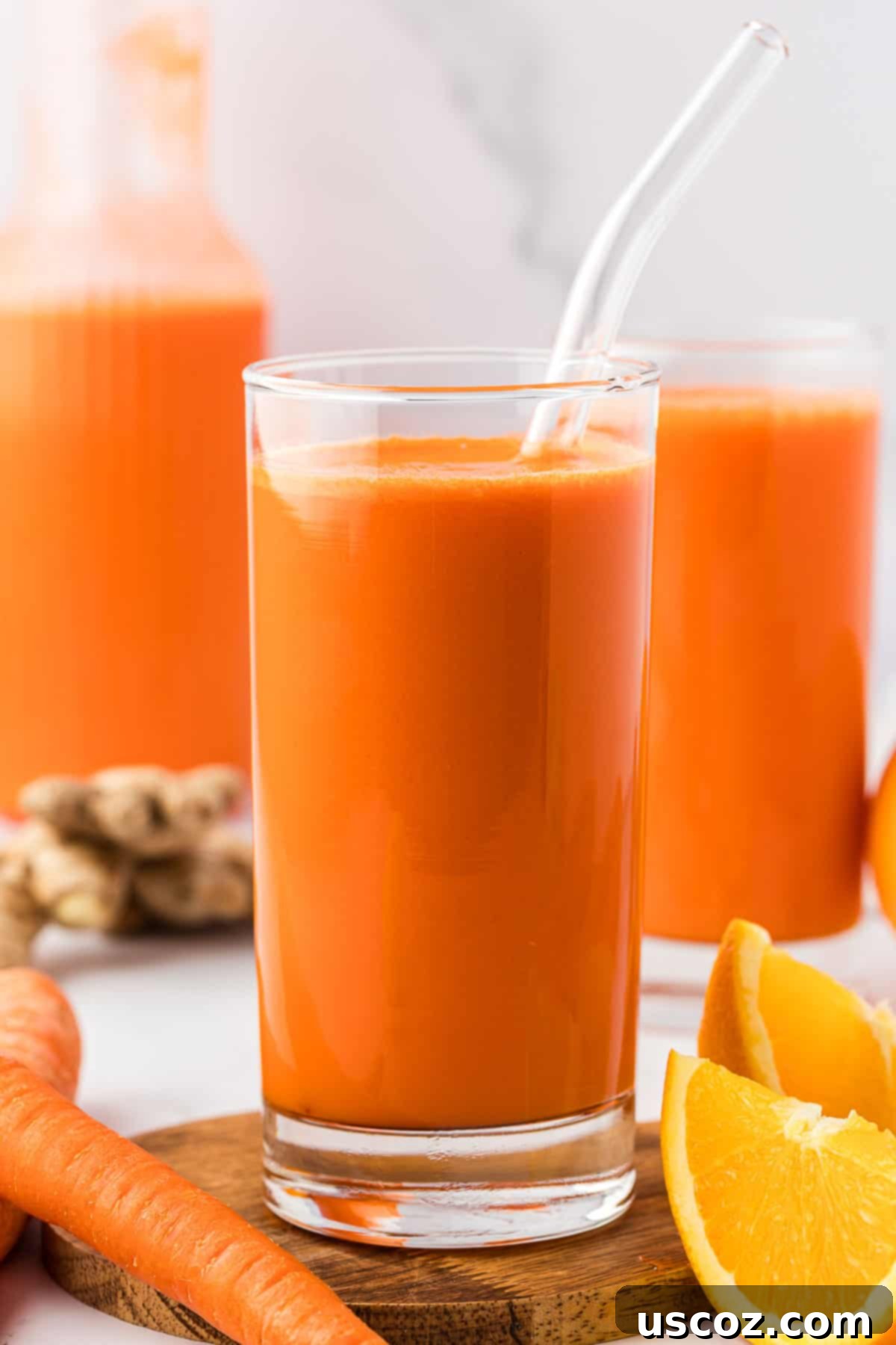 Golden Glow Juice 7 carrot orange juice in a glass with a straw