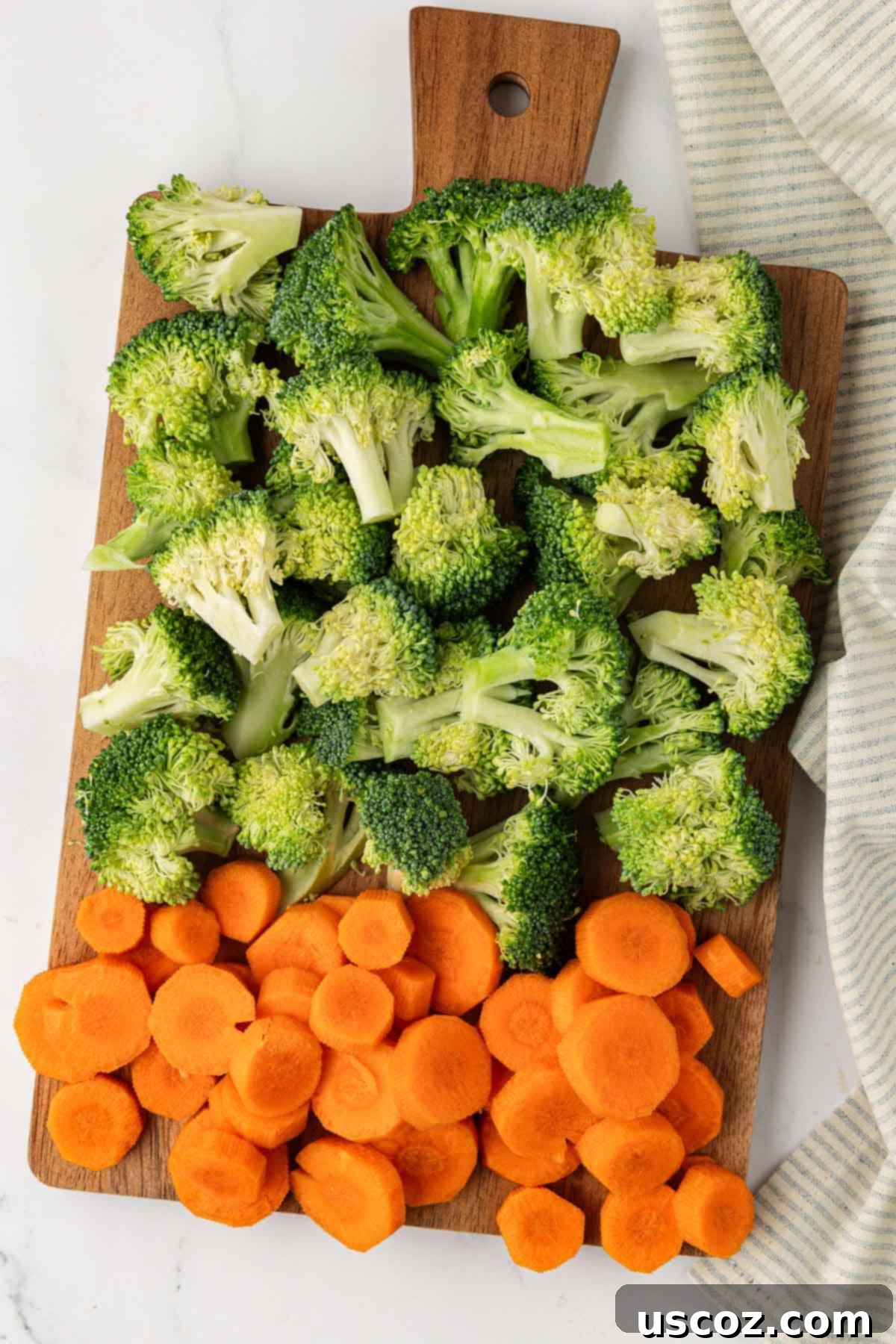 Crispy Roasted Broccoli and Carrots 4 broccoli florets and sliced carrots on a wooden cutting board