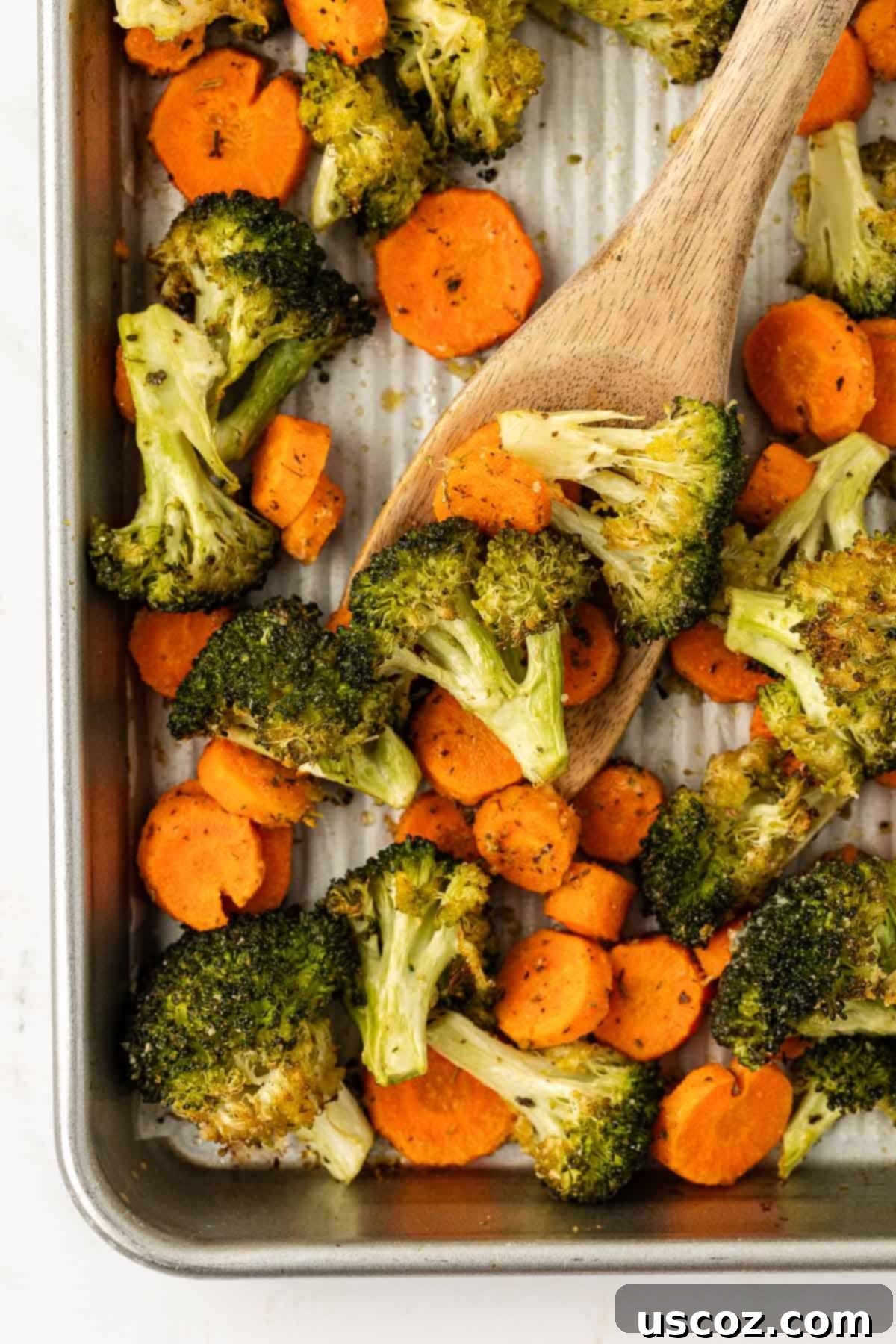 Crispy Roasted Broccoli and Carrots 10 roasted broccoli and carrots on a baking sheet with a wooden spoon for serving