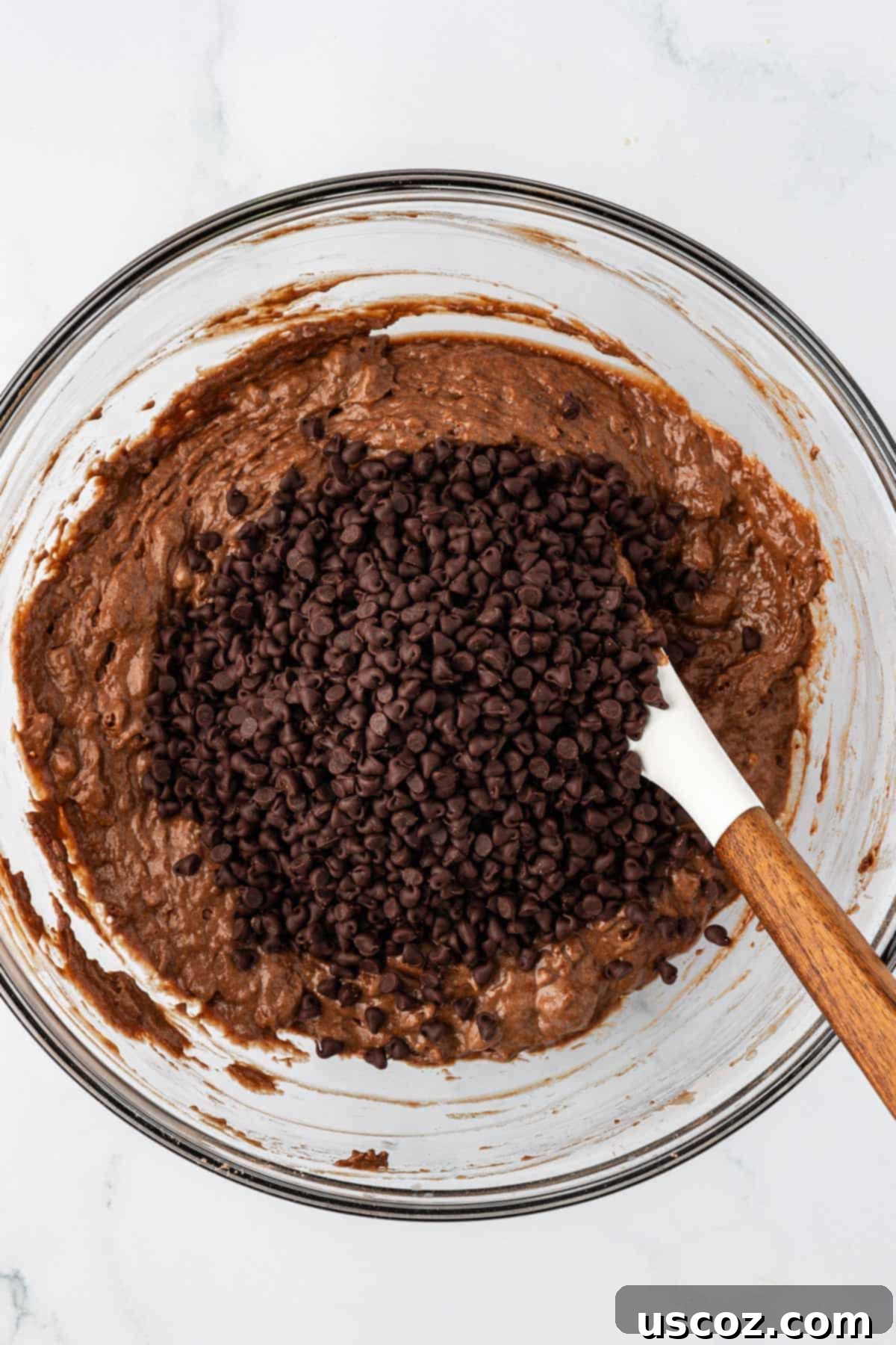 Guilt-Free Chocolate Mini Muffins 11 Adding mini chocolate chips to the healthy chocolate muffin batter.