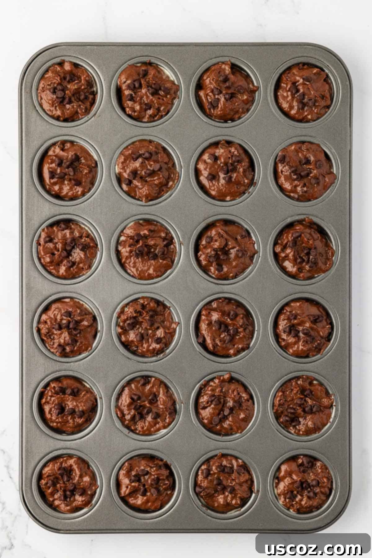 Guilt-Free Chocolate Mini Muffins 13 Chocolate muffin batter being scooped into a mini muffin tin.