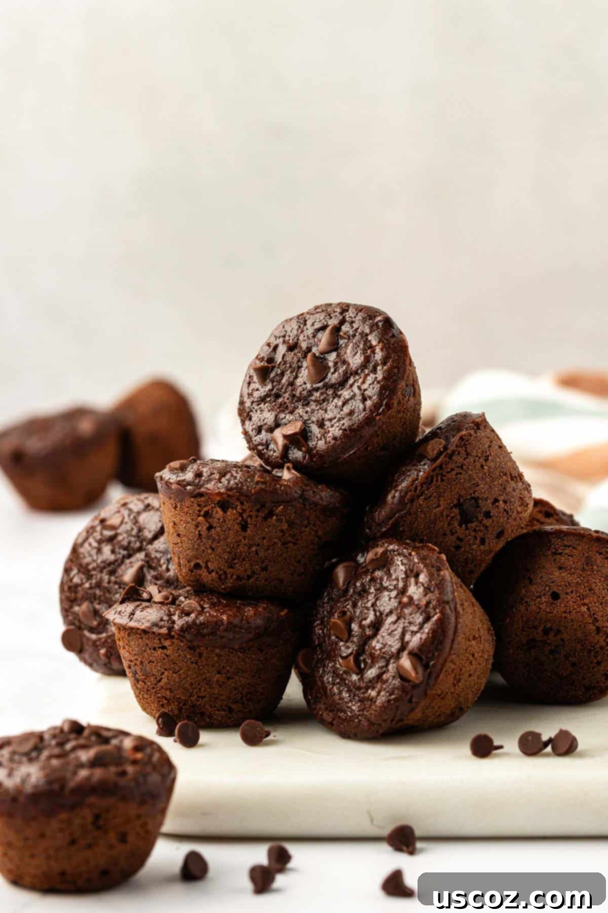 Guilt-Free Chocolate Mini Muffins 17 A top-down view of healthy chocolate mini muffins, some stacked, showcasing their texture.
