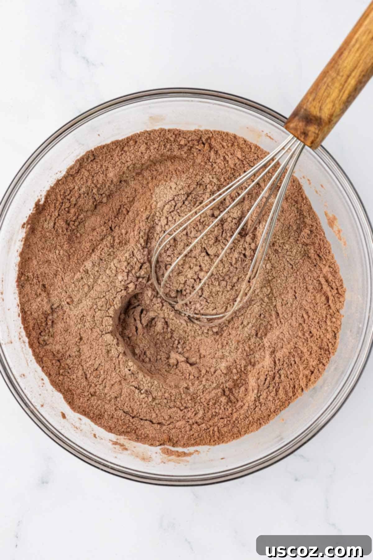 Guilt-Free Chocolate Mini Muffins 6 Dry ingredients for chocolate muffins, including flour and cocoa powder, whisked together.