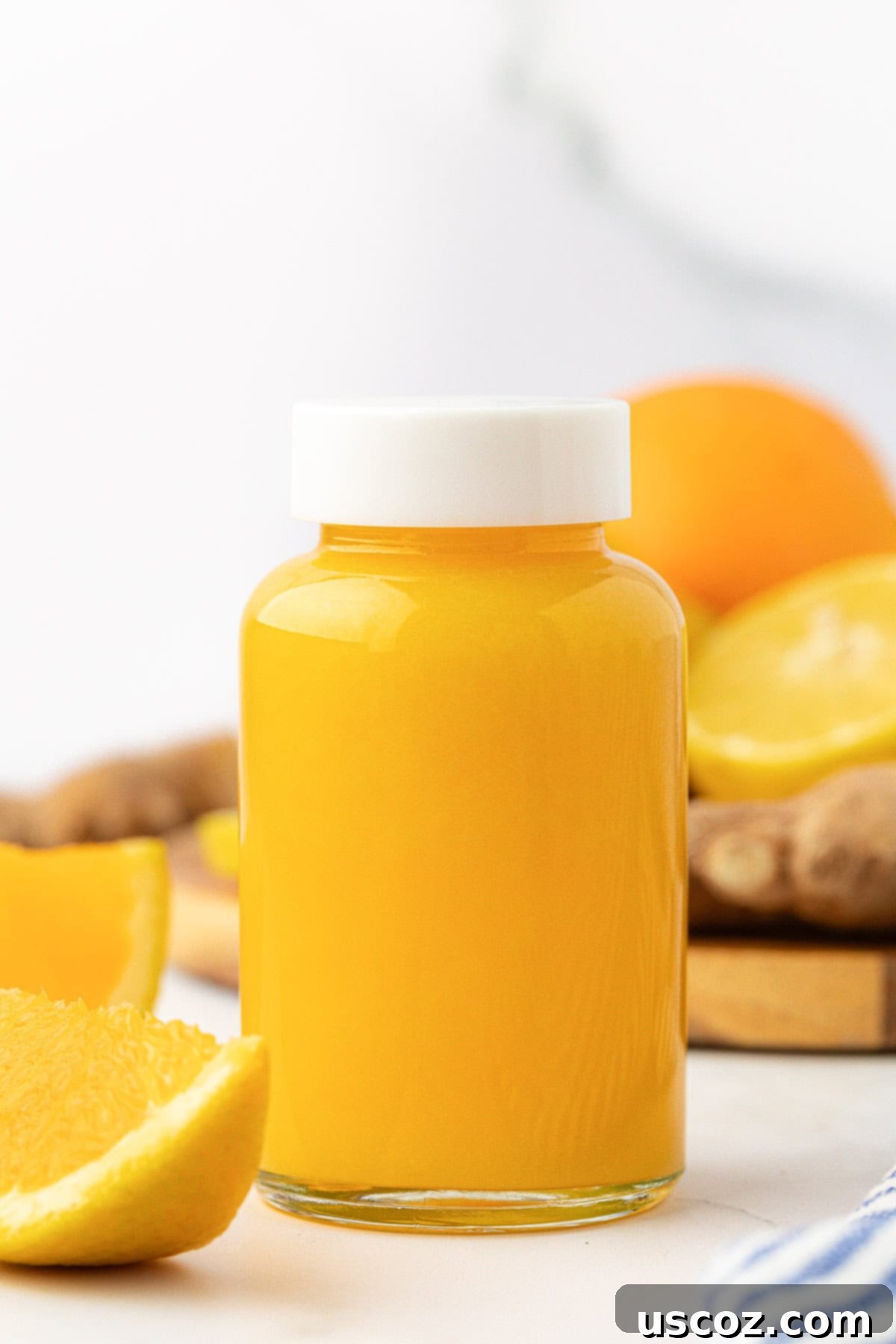 Immune Boost Shots 2 Freshly made citrus ginger immunity shots in small glass jars, ready to drink.