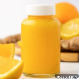 Immune Boost Shots 10 A close up of a single glass bottle filled with a bright orange citrus ginger immunity shot.