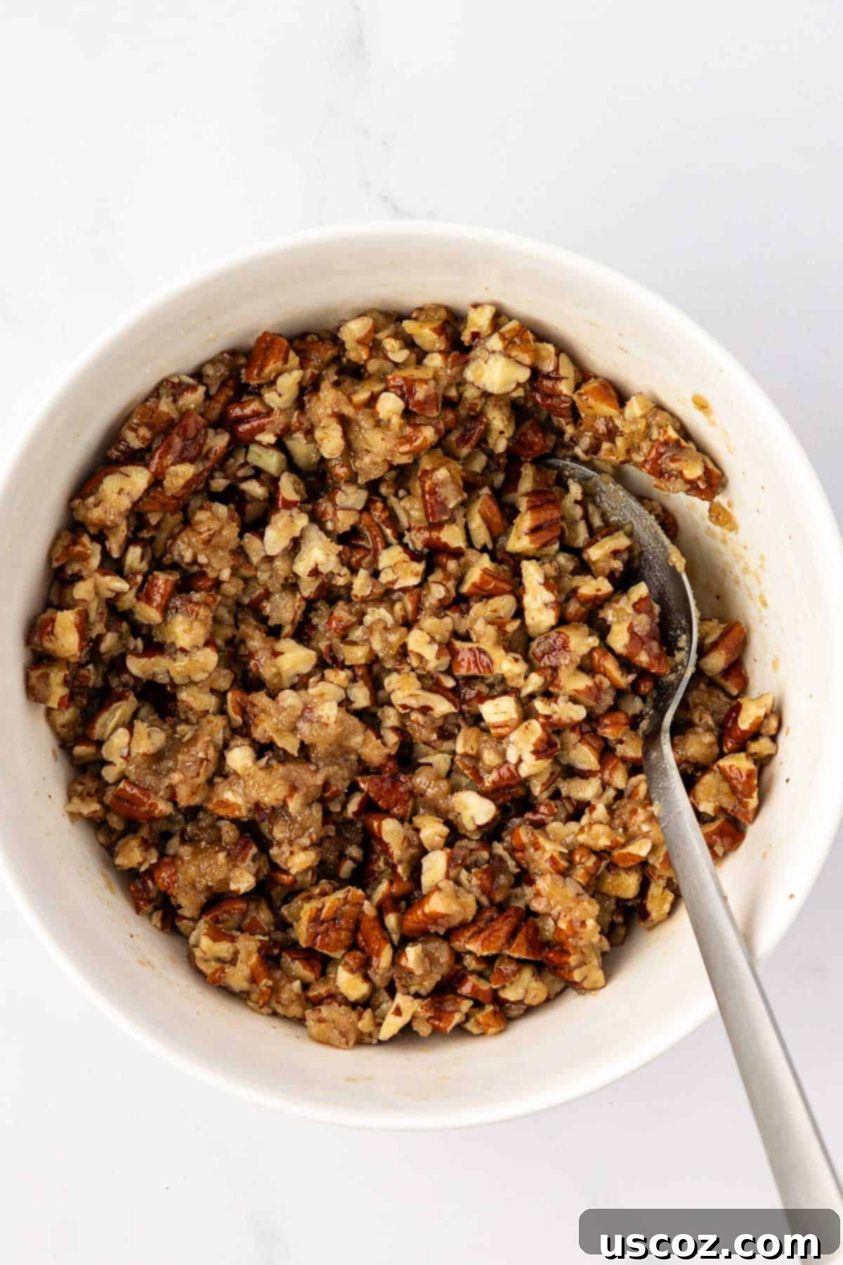 Golden Sweet Potato & Pecan Delight 10 Finely chopped pecan pieces fully mixed with butter, brown sugar, flour, and salt, creating a rich and textured crumble topping in a bowl.