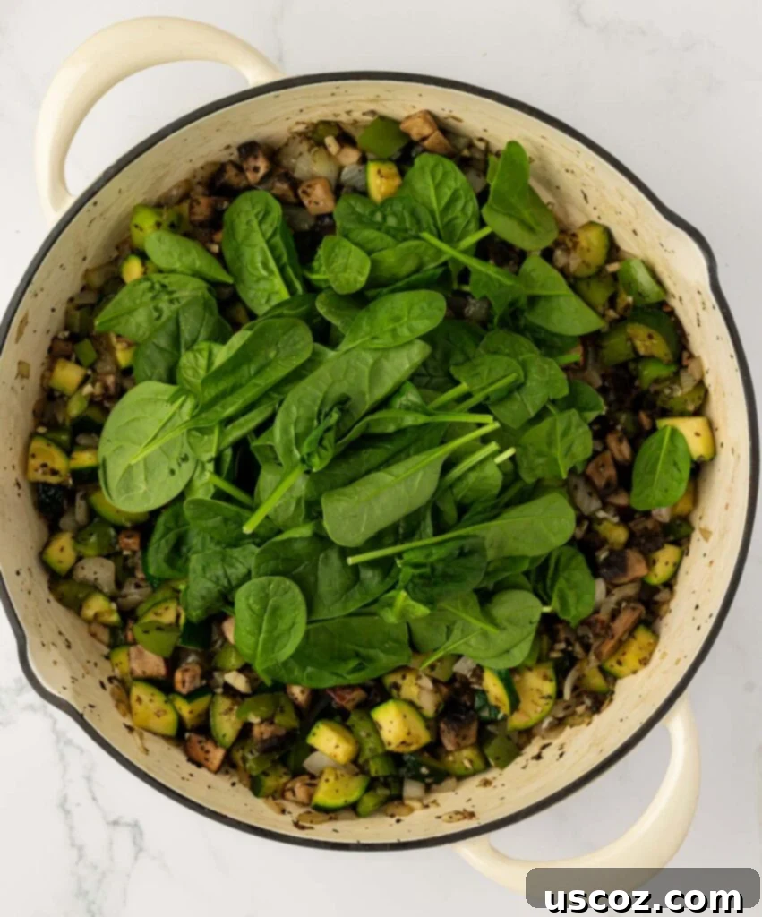 adding spinach to the vegetables