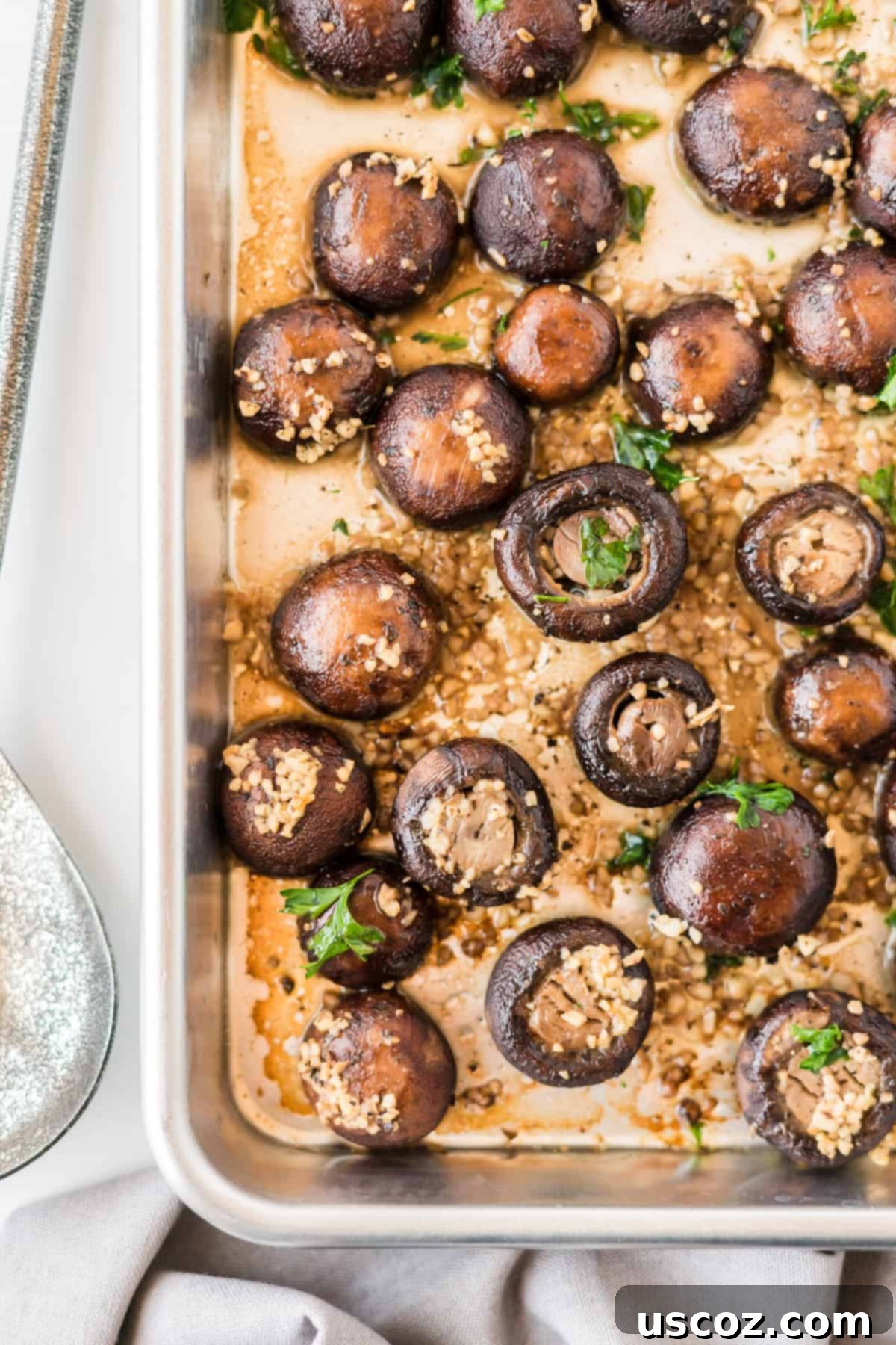 Garlicky Roasted Mushrooms 6 close up of roasted garlic mushrooms on a baking sheet, with a fork digging in