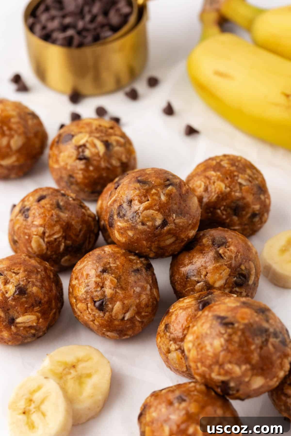 Banana Bread Energy Bites 10 Hand holding a banana bread energy bite with more on a plate