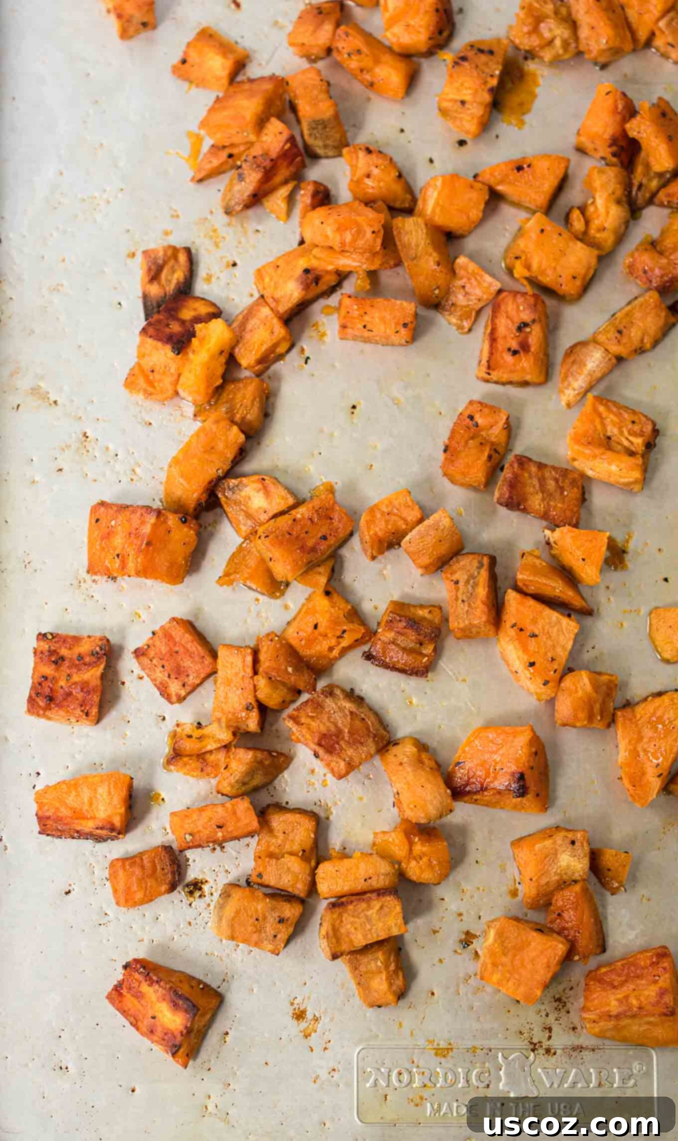 Golden Roasted Sweet Potato Bites 7 A large batch of roasted sweet potatoes scattered on a baking sheet, showcasing their abundant versatility for any meal.