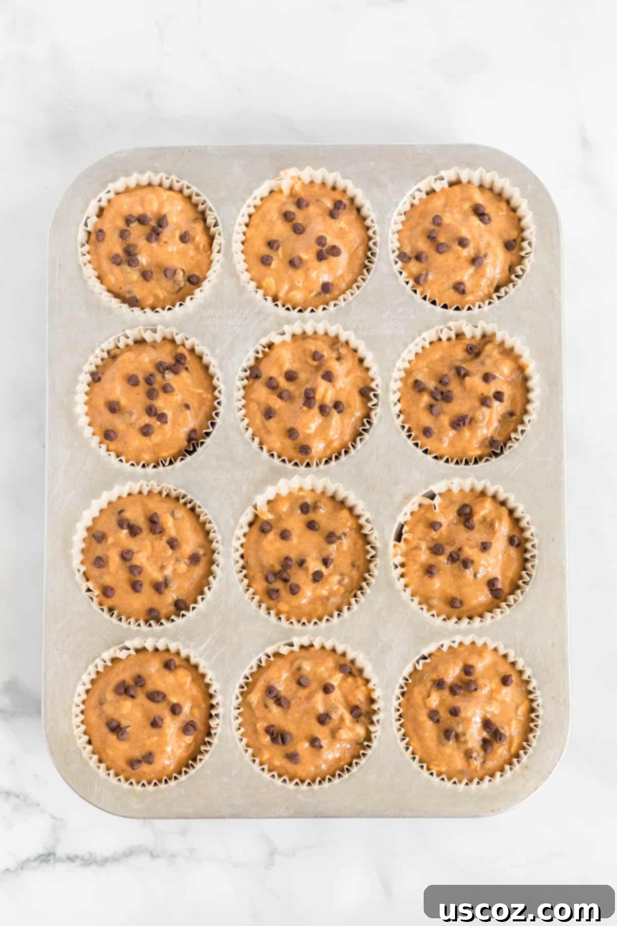 Guilt-Free Pumpkin Chocolate Chip Muffins 9 Pumpkin muffin batter in lined muffin tins, ready for the oven
