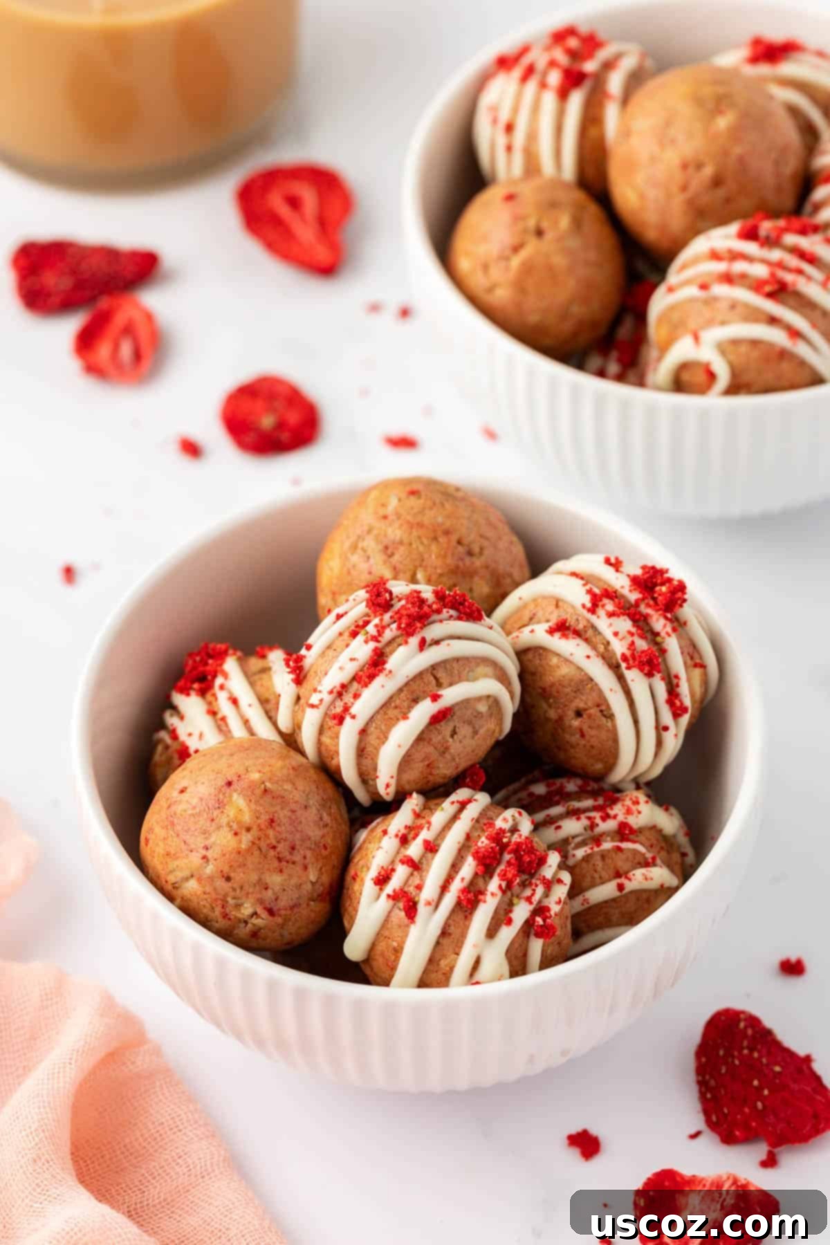 Strawberry Cream Energy Bites 11 several strawberries and cream energy bites stacked neatly on a wooden surface