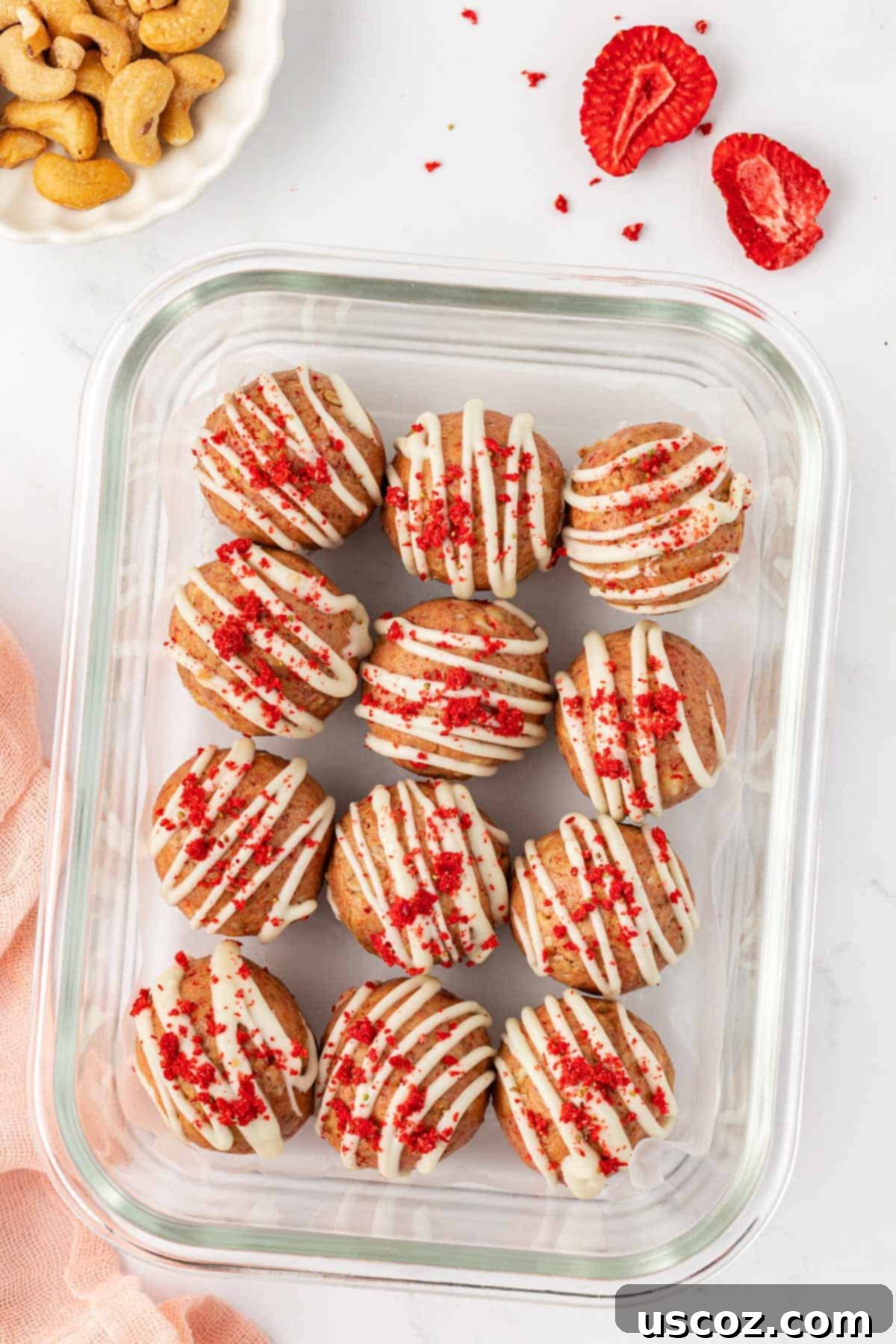 Strawberry Cream Energy Bites 10 strawberries and cream energy bites neatly arranged in a glass storage container
