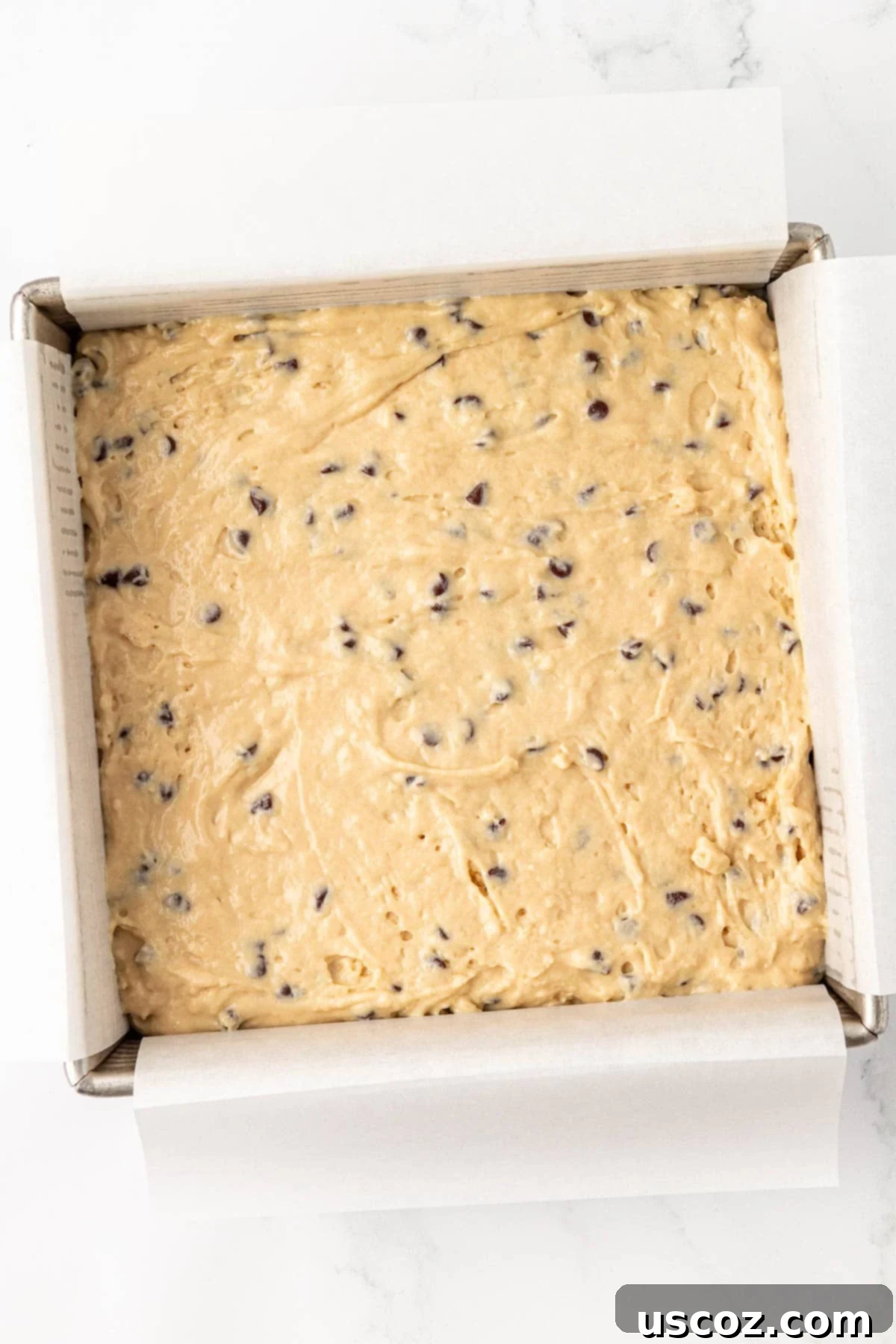 Wholesome Greek Yogurt Cake 15 Greek yogurt cake batter in an 8x8 baking dish lined with parchment paper