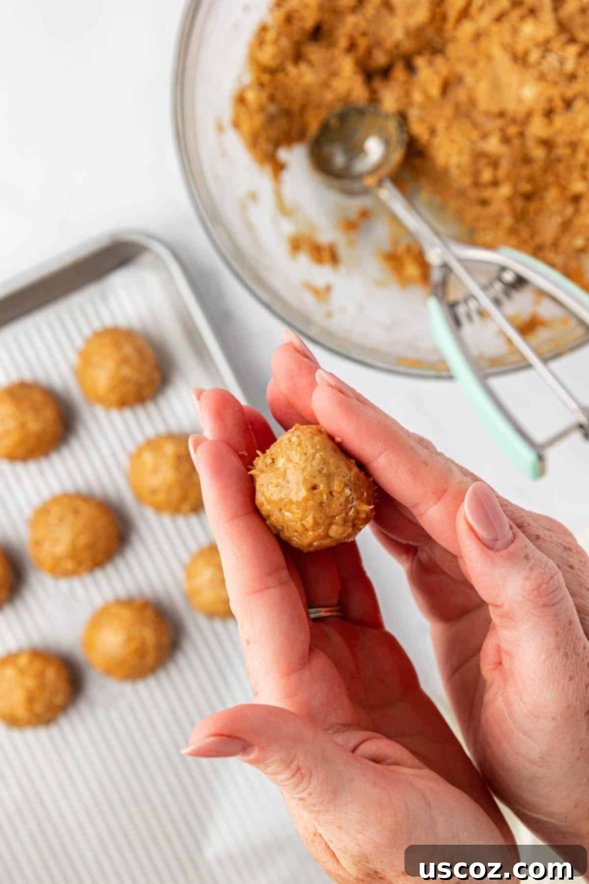 Crunchy Peanut Butter Power Bites 7 Hands rolling a sticky peanut butter protein ball into a smooth sphere.