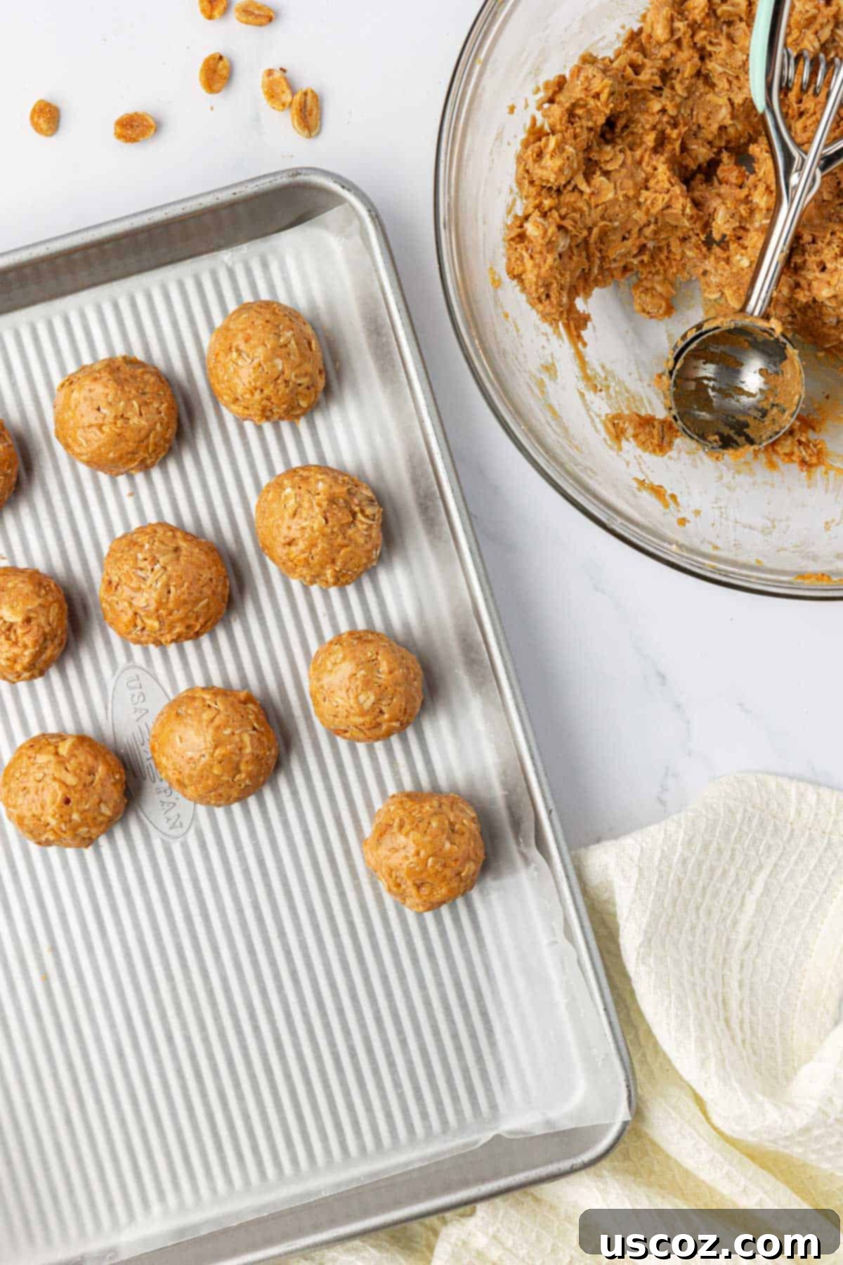 Crunchy Peanut Butter Power Bites 8 A baking sheet filled with freshly rolled peanut butter protein balls, awaiting chocolate drizzle.
