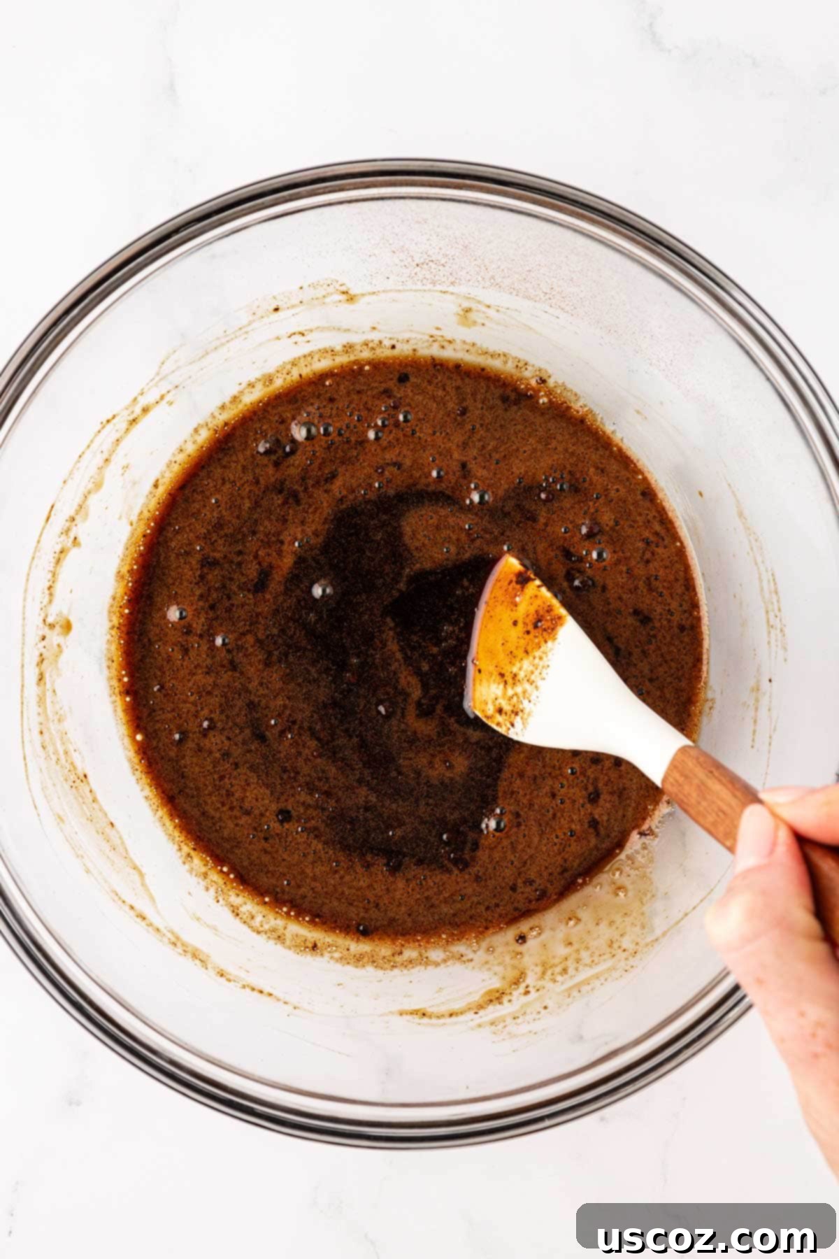 Espresso Boost Bites 6 Stirring instant espresso powder into maple syrup with a rubber spatula