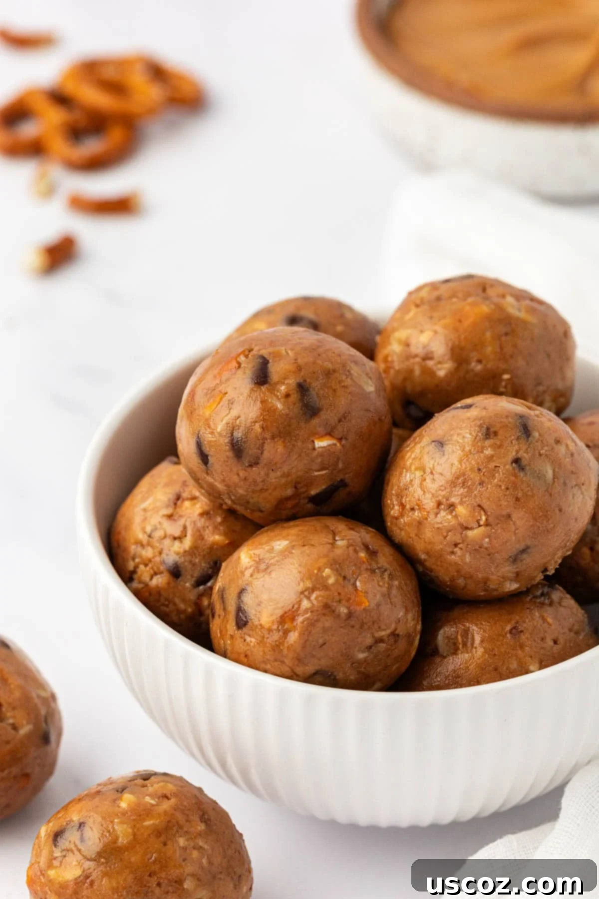 Peanut Butter Pretzel Power Bites 2 Delicious homemade peanut butter pretzel energy bites stacked on a rustic plate, ready for snacking