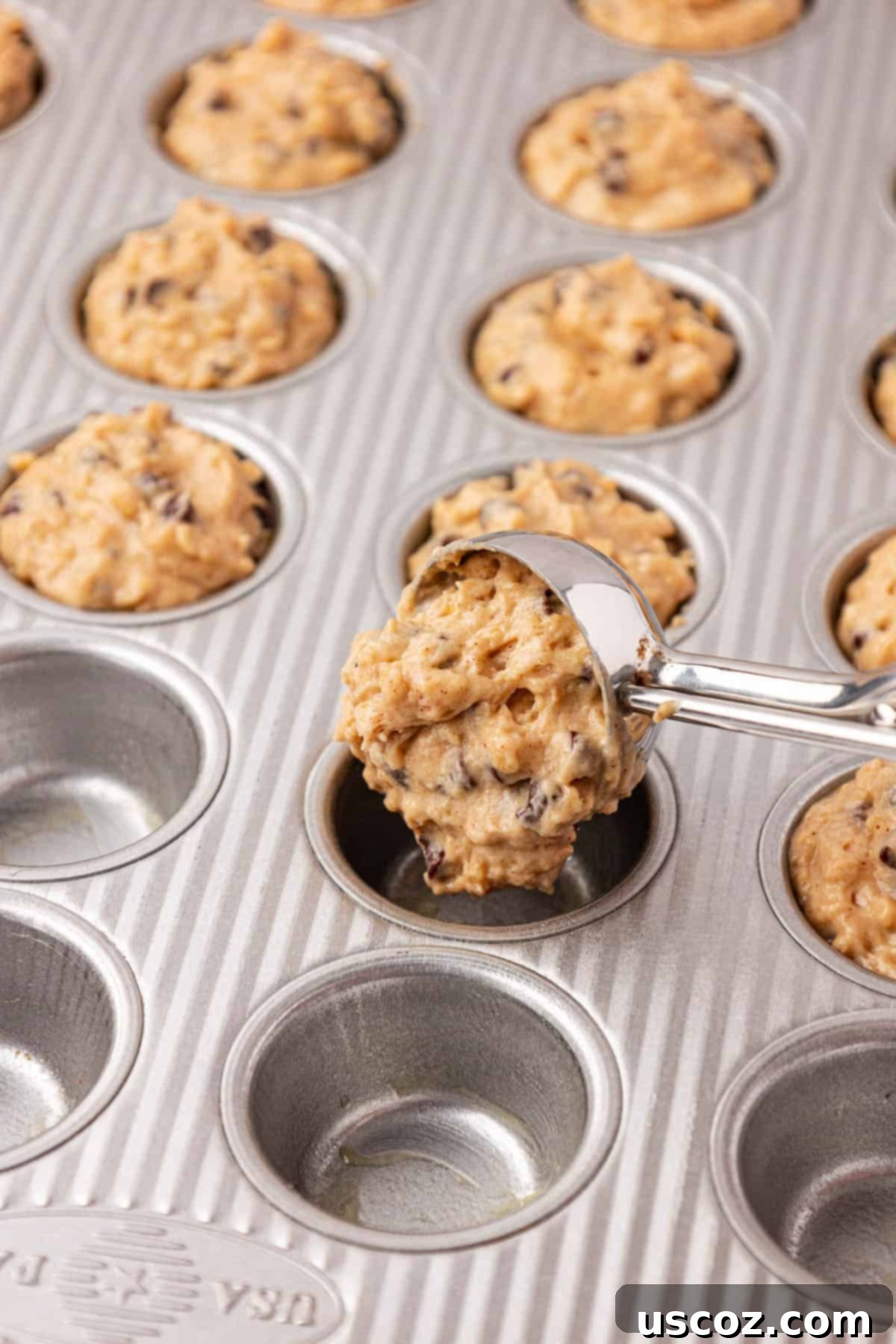 Oatmeal Cookie Muffin Bites 13 using a mini cookie scoop to fill the mini muffin tin with batter