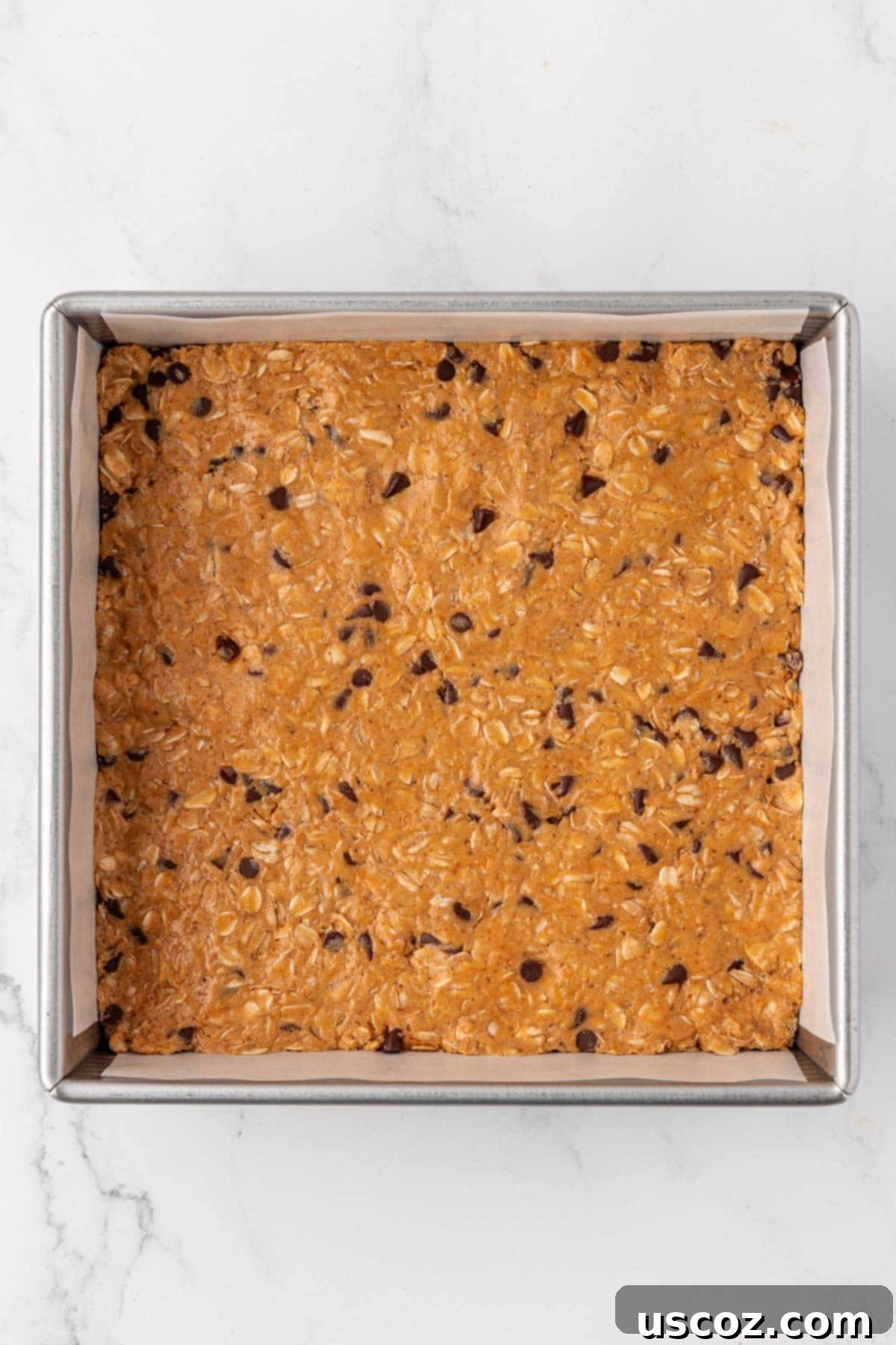 Power-Packed Protein Granola Bars 9 Protein granola bar batter pressed firmly into a parchment-lined 8x8 inch pan