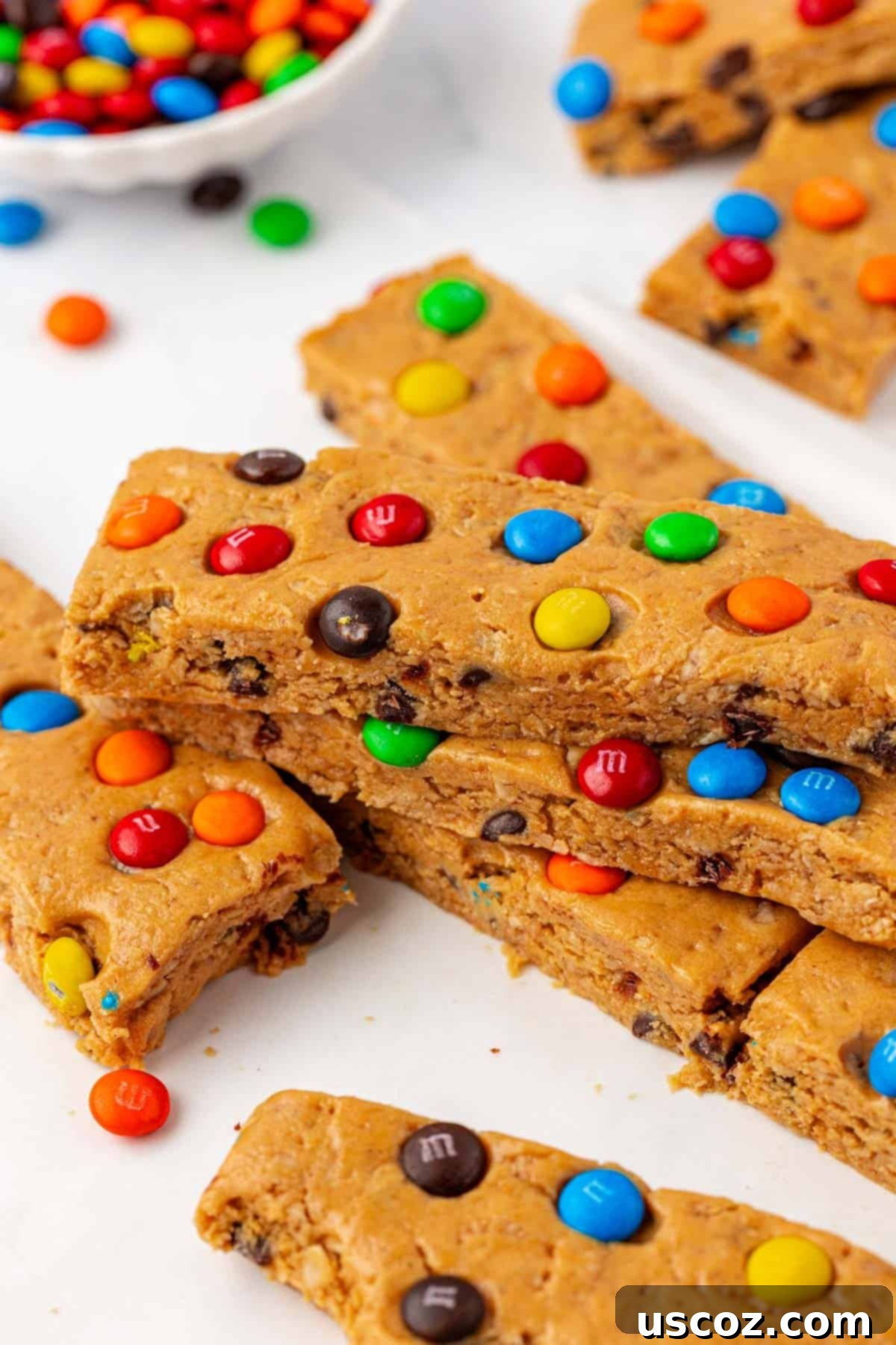 Monster Cookie Protein Bars 11 A hand holding a Monster Cookie Protein Bar, showcasing its texture and toppings