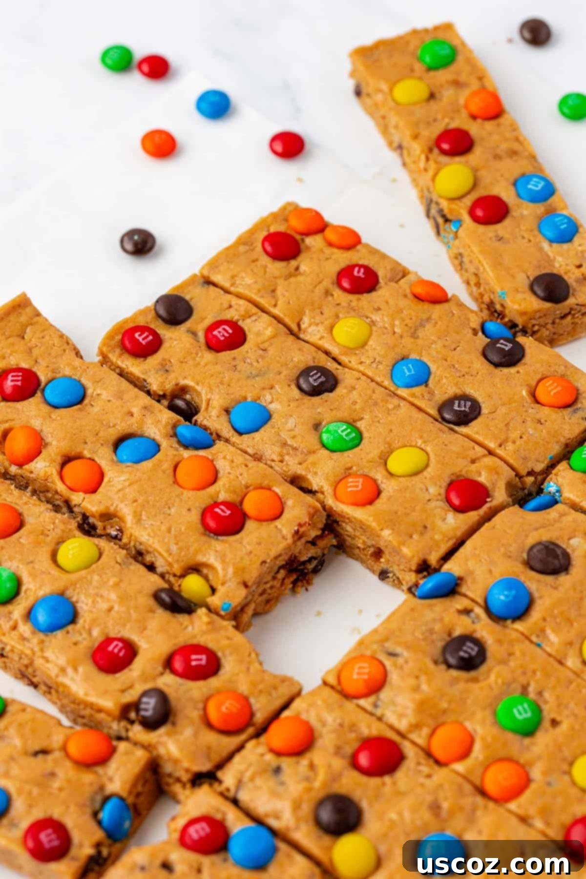 Monster Cookie Protein Bars 3 Two Monster Cookie Protein Bars stacked on a plate, showcasing their texture and toppings