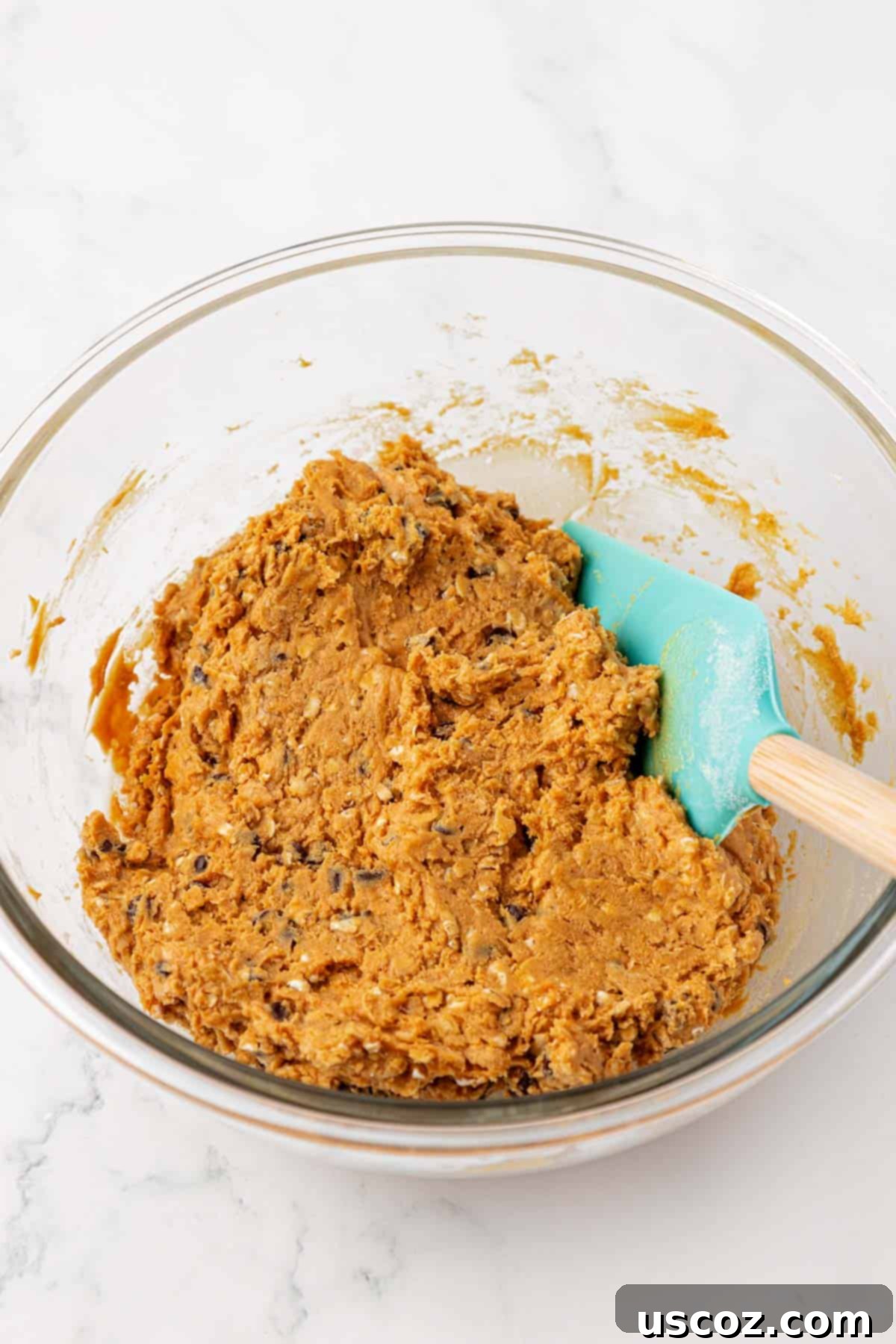 Monster Cookie Protein Bars 6 Thick monster cookie protein bar batter mixed together in a bowl with a rubber spatula