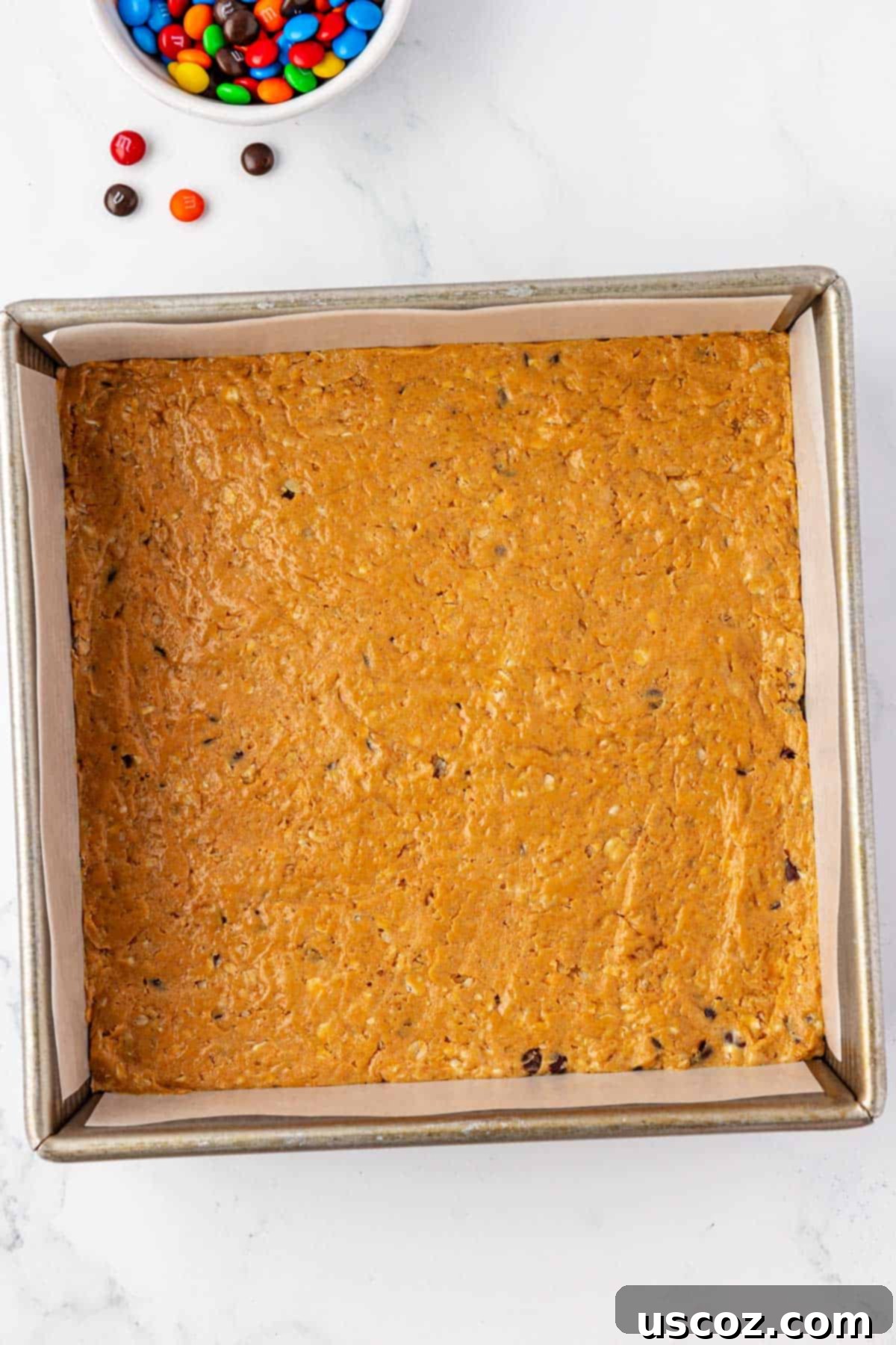 Monster Cookie Protein Bars 8 Monster cookie protein bar batter with M&Ms pressed into the top, ready for chilling