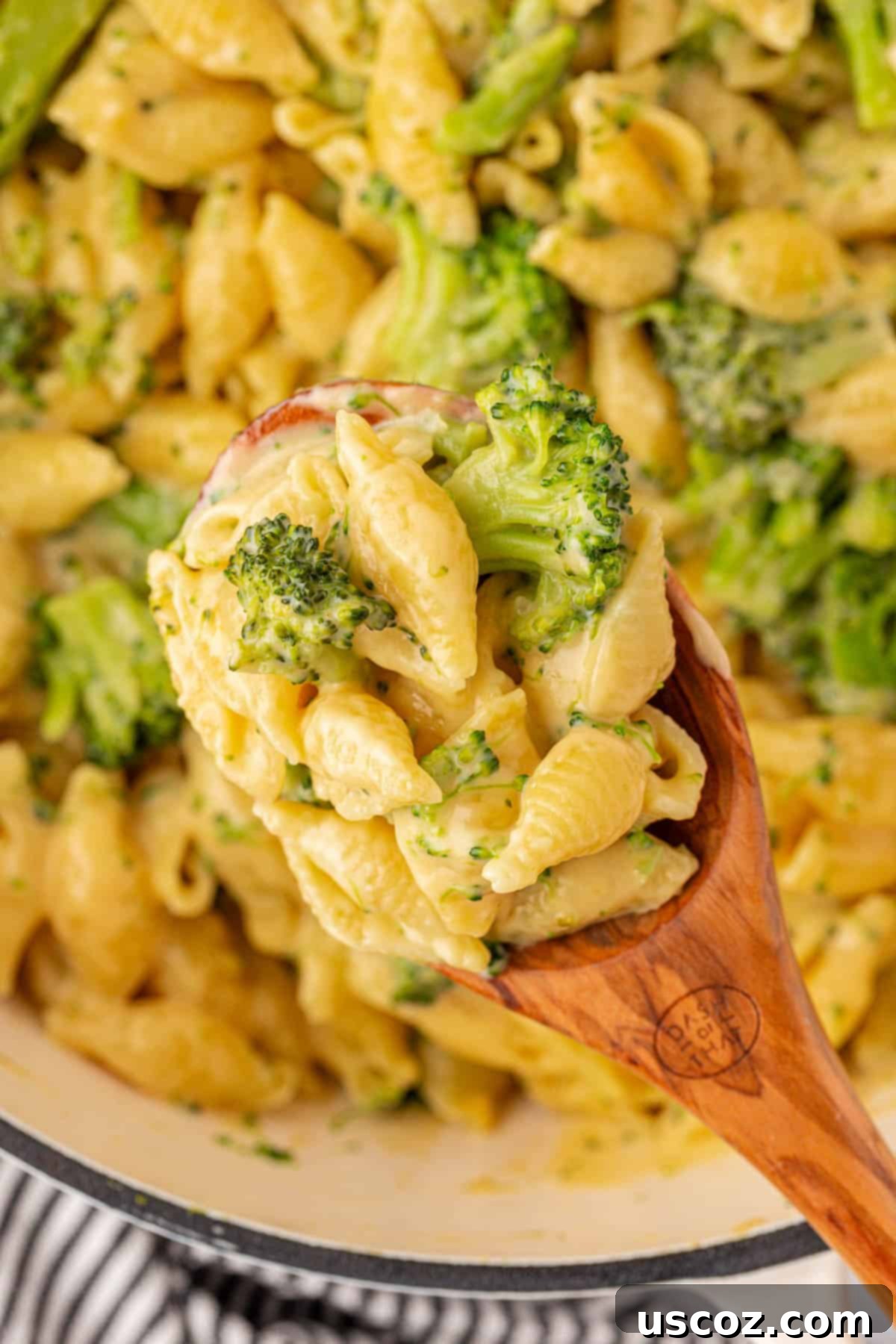 scooping broccoli mac and cheese from the pan