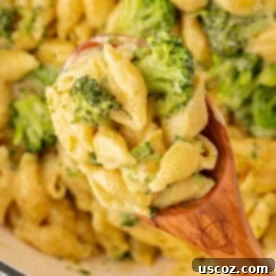 scooping broccoli mac and cheese from the pan