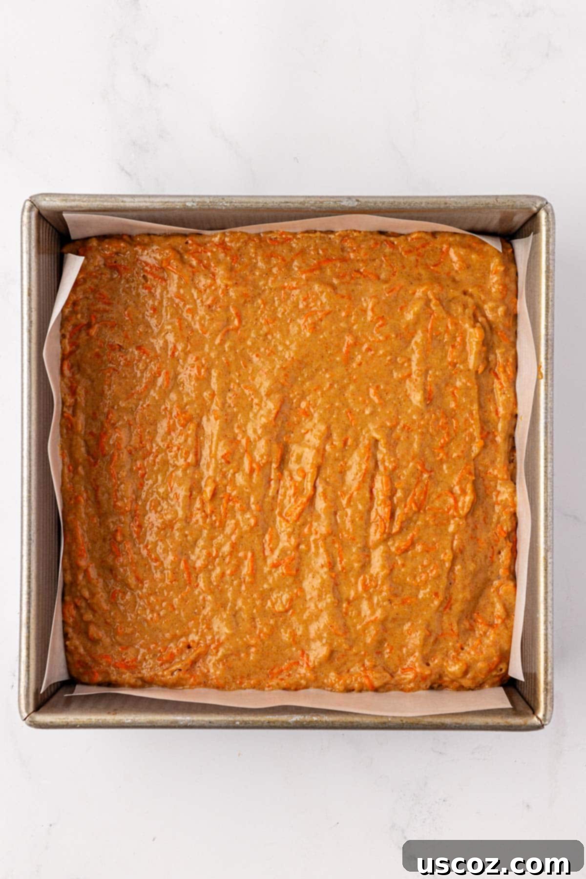 Wholesome Carrot Cake Bars 11 carrot cake bar batter spread out in an 8 by 8 dish