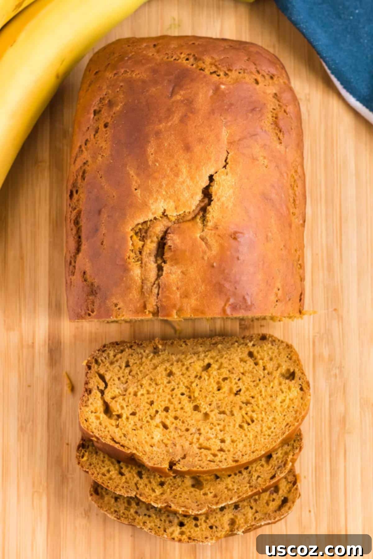 Wholesome Spiced Pumpkin and Banana Bread 11 Another view of pumpkin bread being carefully sliced on a cutting board.