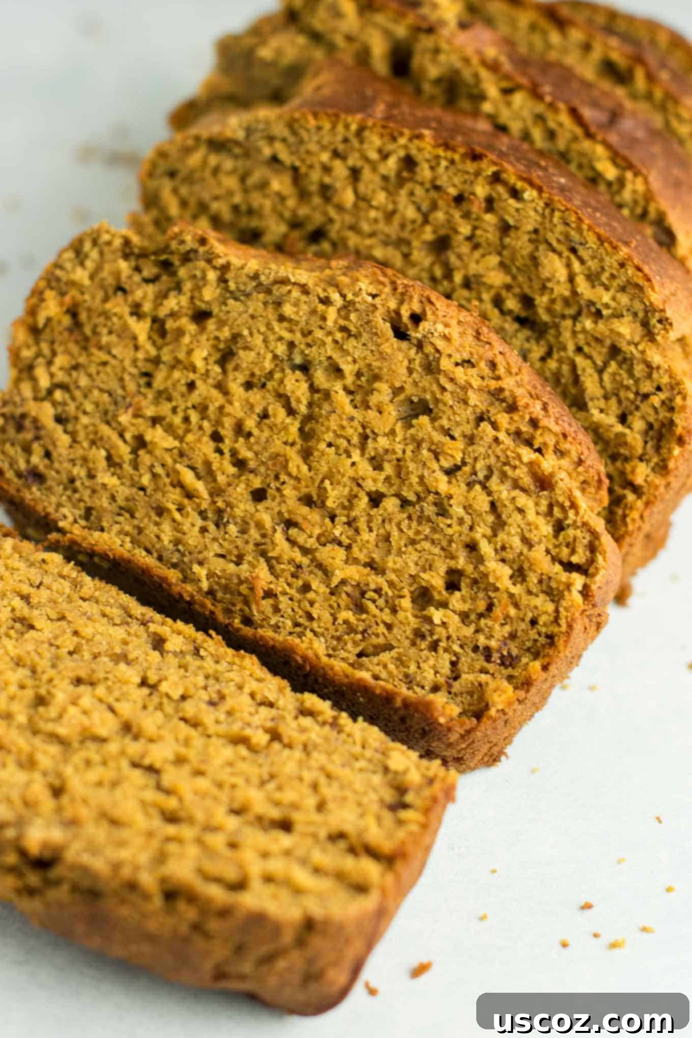 Wholesome Spiced Pumpkin and Banana Bread 4 Close-up of three thick slices of healthy pumpkin banana bread, showcasing its moist texture and golden-brown crust.