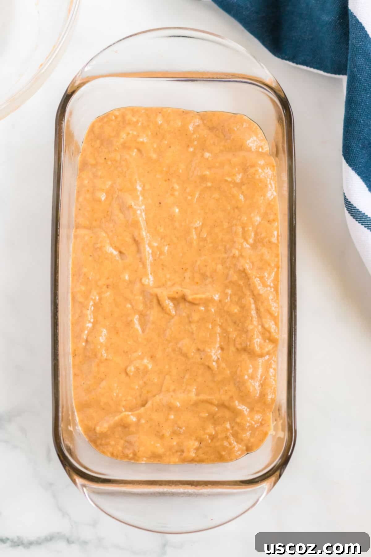 Wholesome Spiced Pumpkin and Banana Bread 5 Pumpkin banana bread batter spread into a loaf pan, ready for baking.