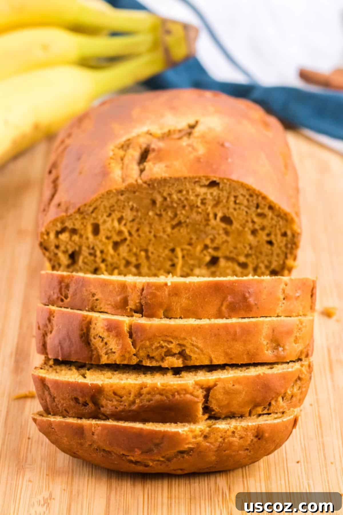 Wholesome Spiced Pumpkin and Banana Bread 9 A hand gently cutting a slice from a freshly baked loaf of healthy pumpkin banana bread.