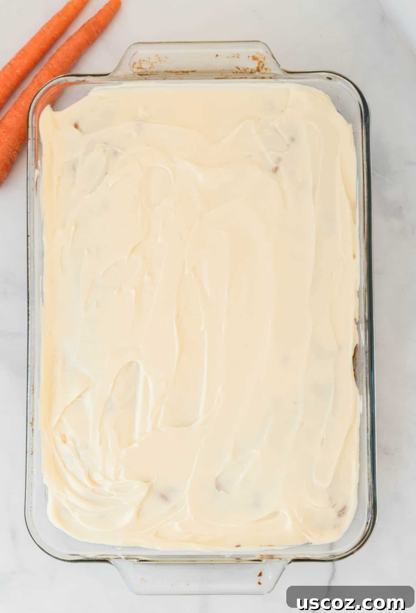Gluten-Free Carrot Cake Perfection 2 Frosted gluten-free carrot cake in a large 9 by 13 baking dish, ready for serving, with a perfect creamy top layer.