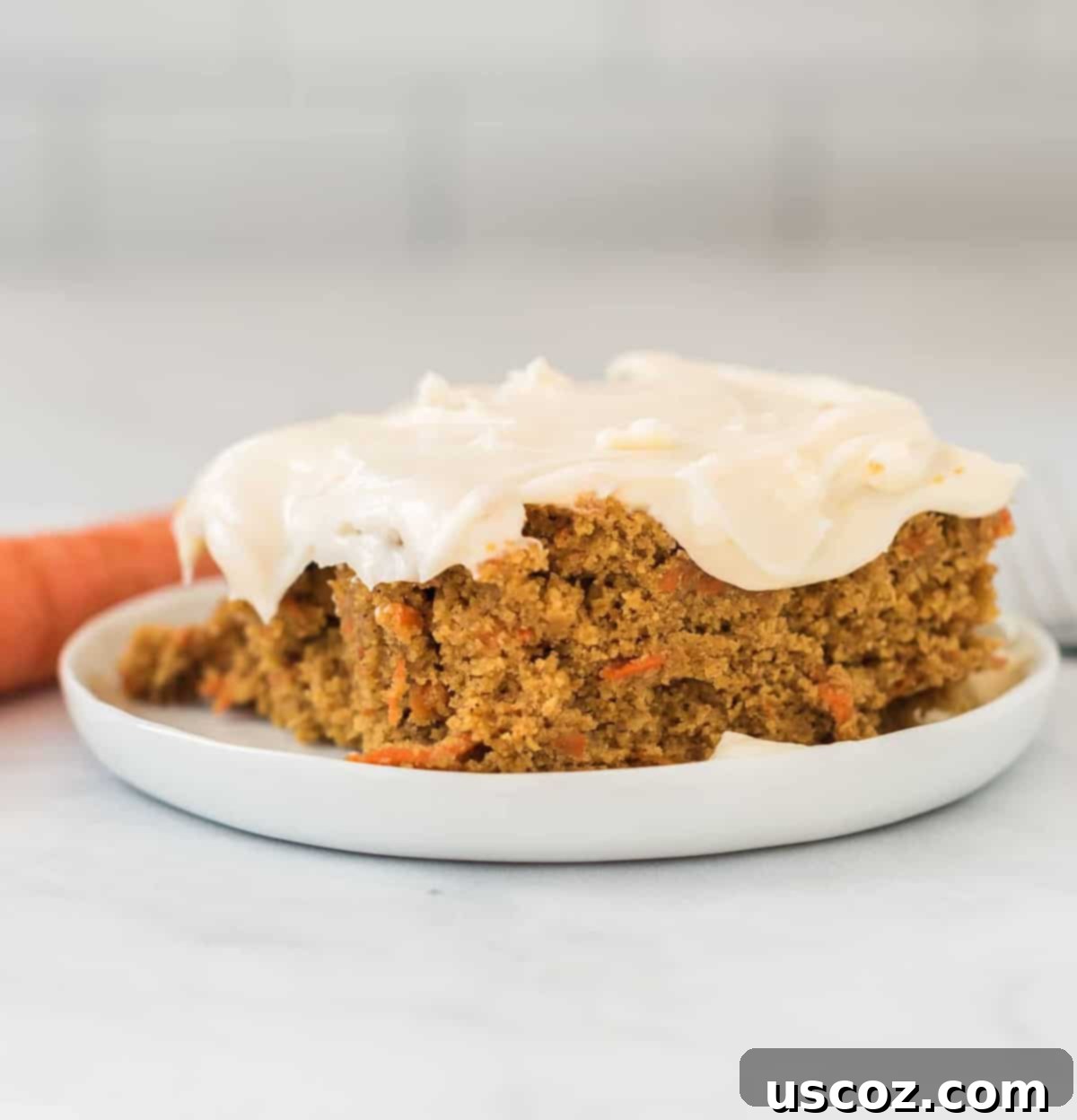 Gluten-Free Carrot Cake Perfection 3 A perfectly sliced piece of gluten-free carrot cake with cream cheese frosting on a white plate, showcasing its moist, spiced texture.