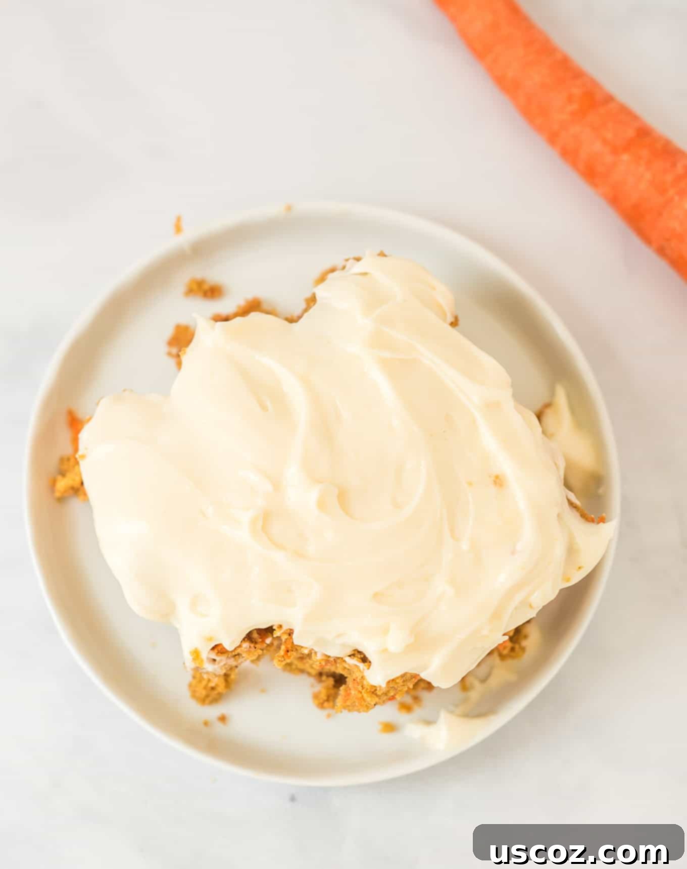 Gluten-Free Carrot Cake Perfection 6 A close-up of a delightful slice of gluten-free carrot cake topped with creamy Greek yogurt cream cheese frosting, ready to savor.