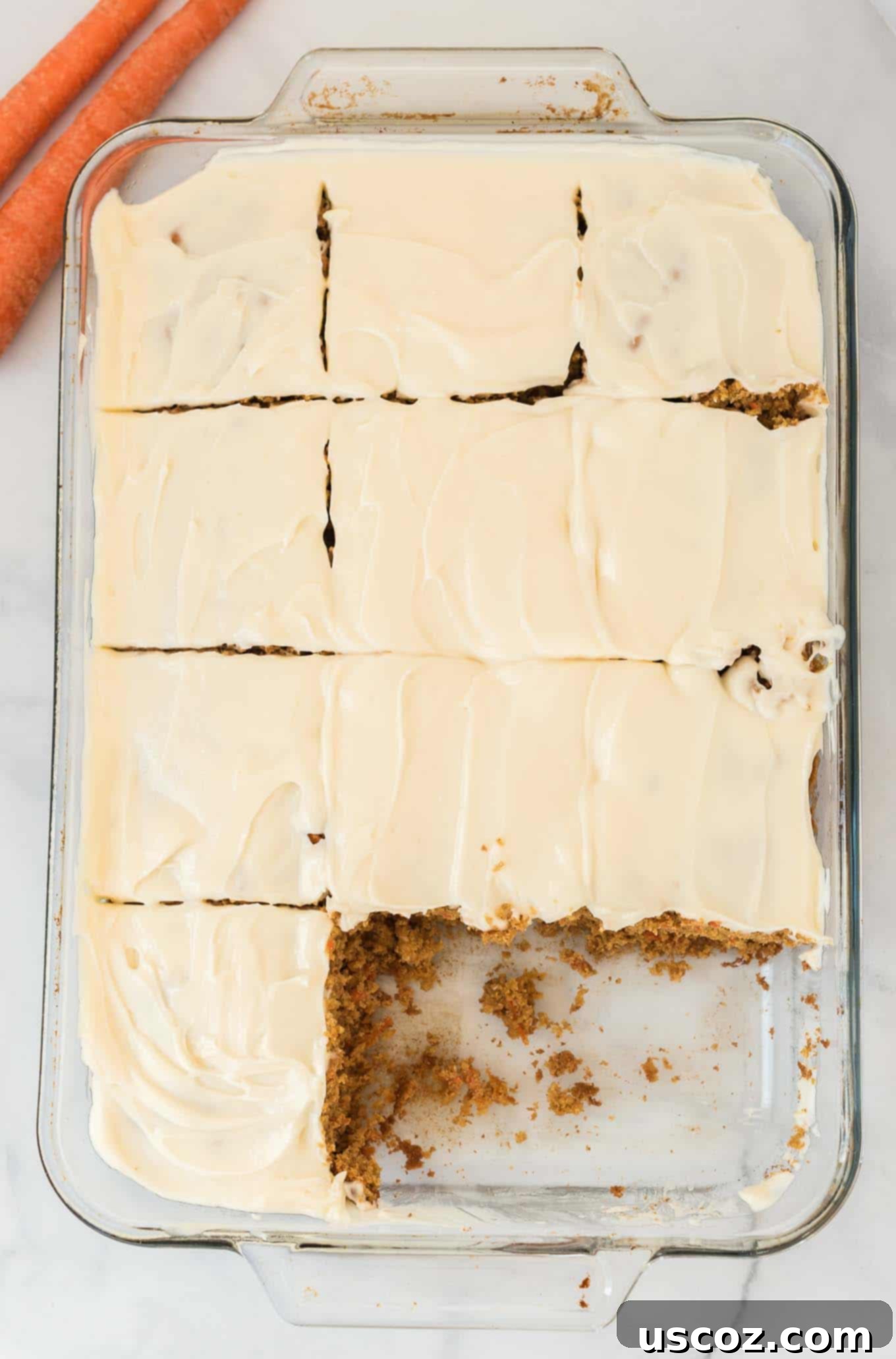 Gluten-Free Carrot Cake Perfection 7 A gluten-free carrot cake in a baking dish with a few slices already enjoyed, revealing the moist interior and thick frosting.