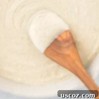 Creamy Cauliflower Alfredo 18 wooden spoon dipped in cauliflower alfredo sauce