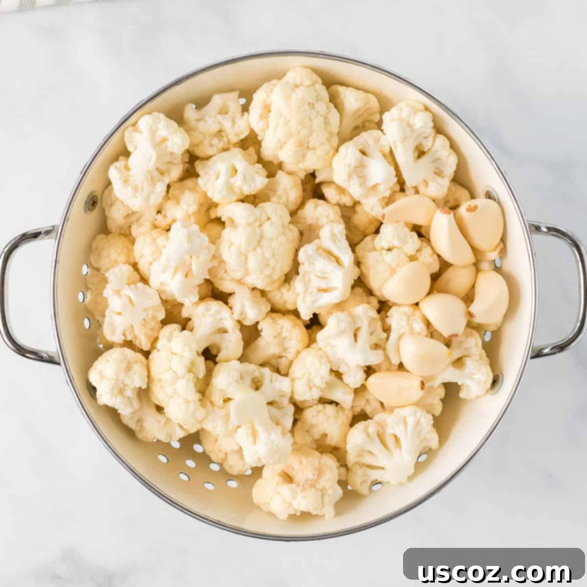 Creamy Cauliflower Alfredo 4 cauliflower florets and garlic cloves in a strainer