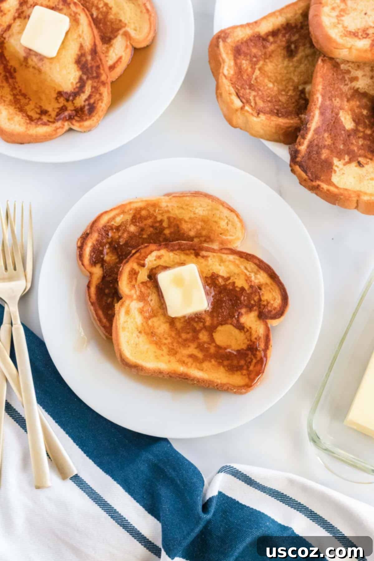 Festive Eggnog French Toast 2 Platter of golden brown eggnog french toast topped with butter and maple syrup, ready for a festive Christmas breakfast