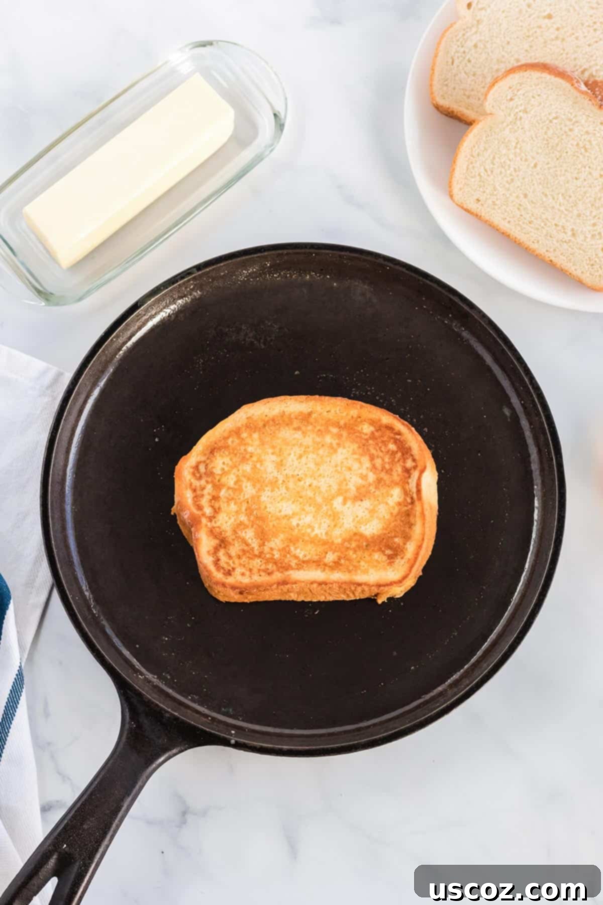 Festive Eggnog French Toast 5 Eggnog French toast cooking to a perfect golden brown in a well-seasoned cast iron skillet