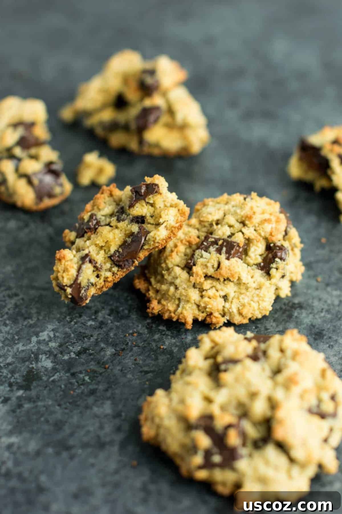 A stack of golden brown Gluten-Free Oatmeal Chocolate Chip Cookies with melted chocolate chips, made with oat and coconut flour.