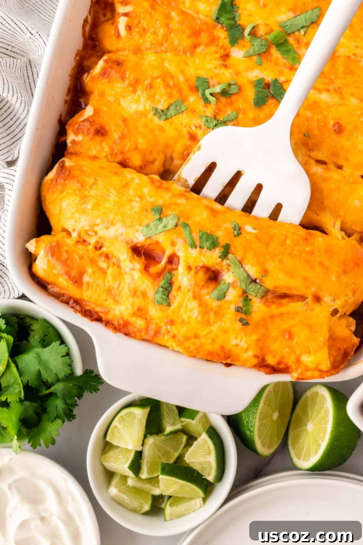 Southwestern Sweet Potato Black Bean Enchiladas 17 Spatula scooping a portion of sweet potato black bean enchiladas from the baking pan