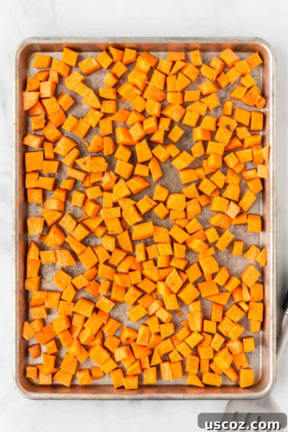 Southwestern Sweet Potato Black Bean Enchiladas 5 Sweet potato cubes prepared on a baking sheet for roasting