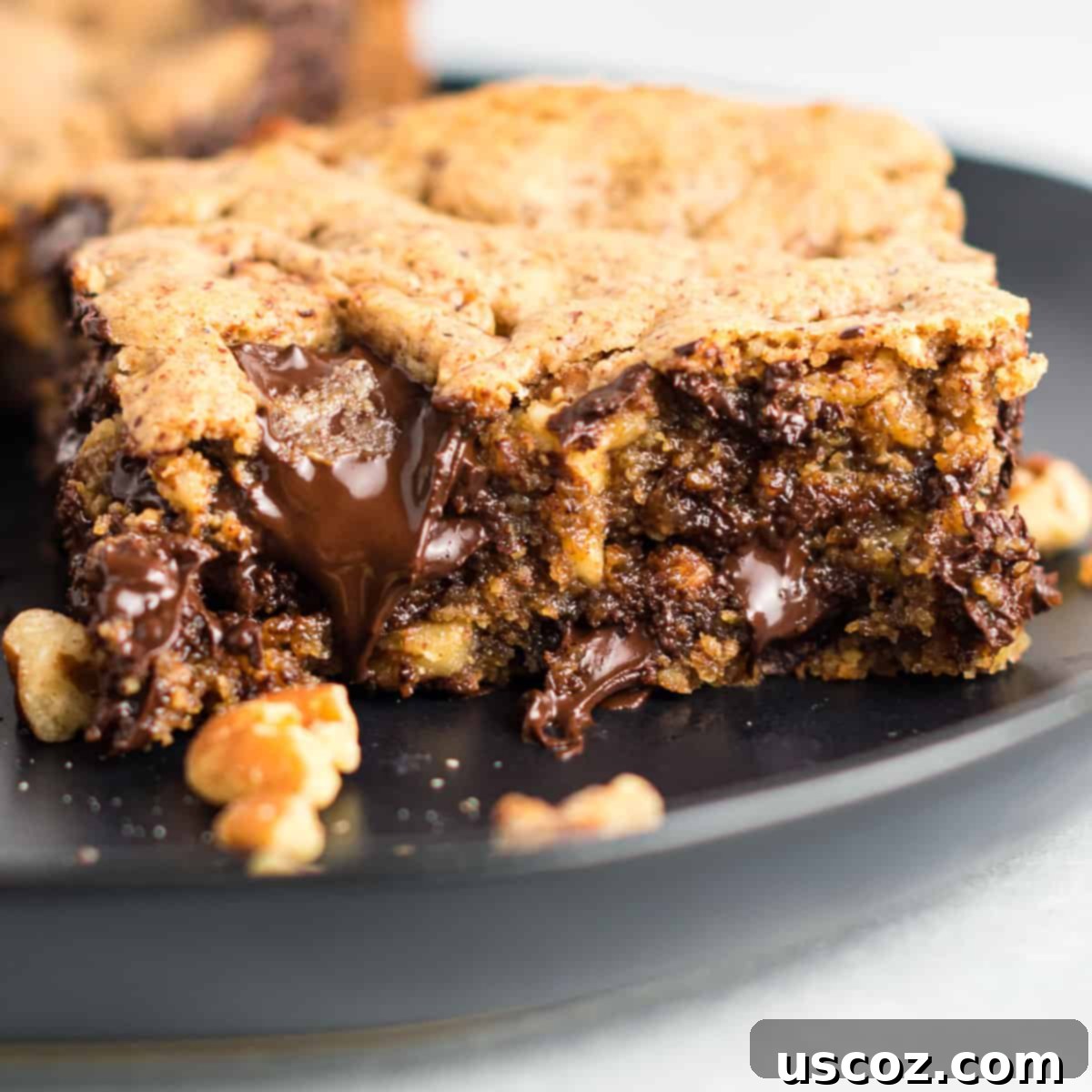 Decadent Dark Chocolate Pecan Cookie Bars 2 Gluten-free dark chocolate pecan cookie bar on a white plate, showcasing its rich texture
