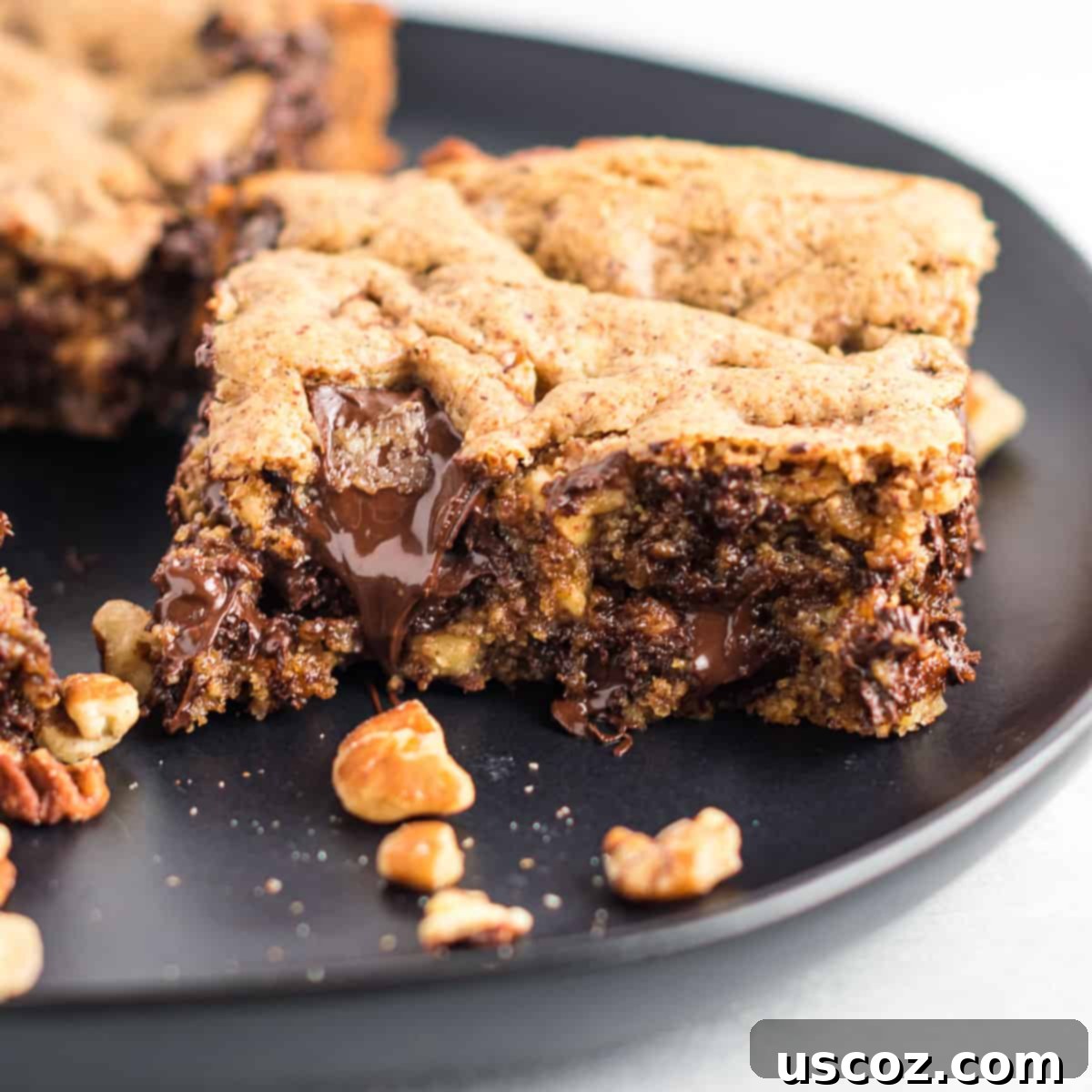Decadent Dark Chocolate Pecan Cookie Bars 6 A single gluten-free dark chocolate pecan cookie bar with a bite taken out